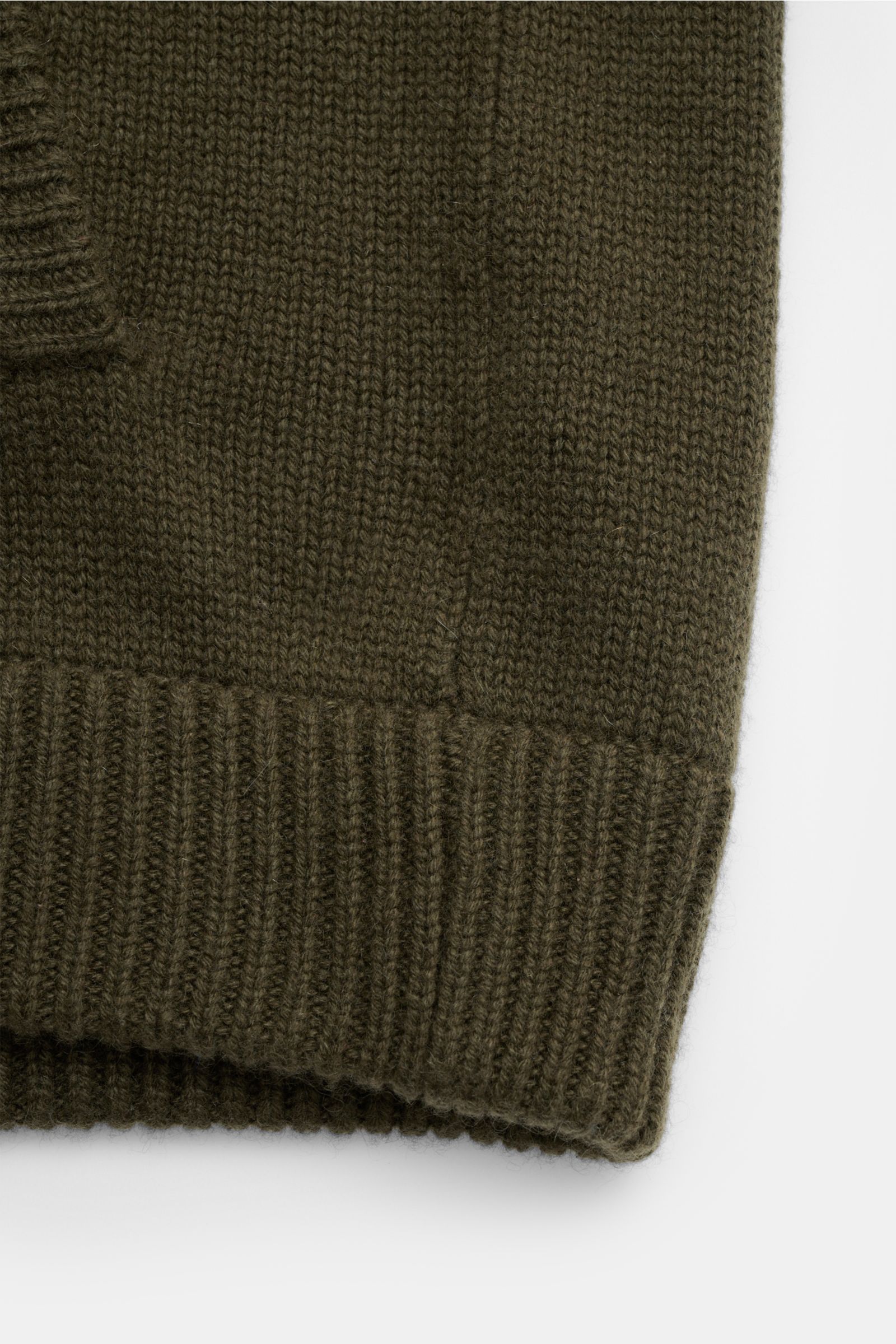 Nahaufnahme des von Braun Cashmere Cardigan oliv von unten, zeigt weichen Griff, mittelfeines Strickbild, Rippbündchen, Slim Fit, reine mongolische Cashmere-Qualität.