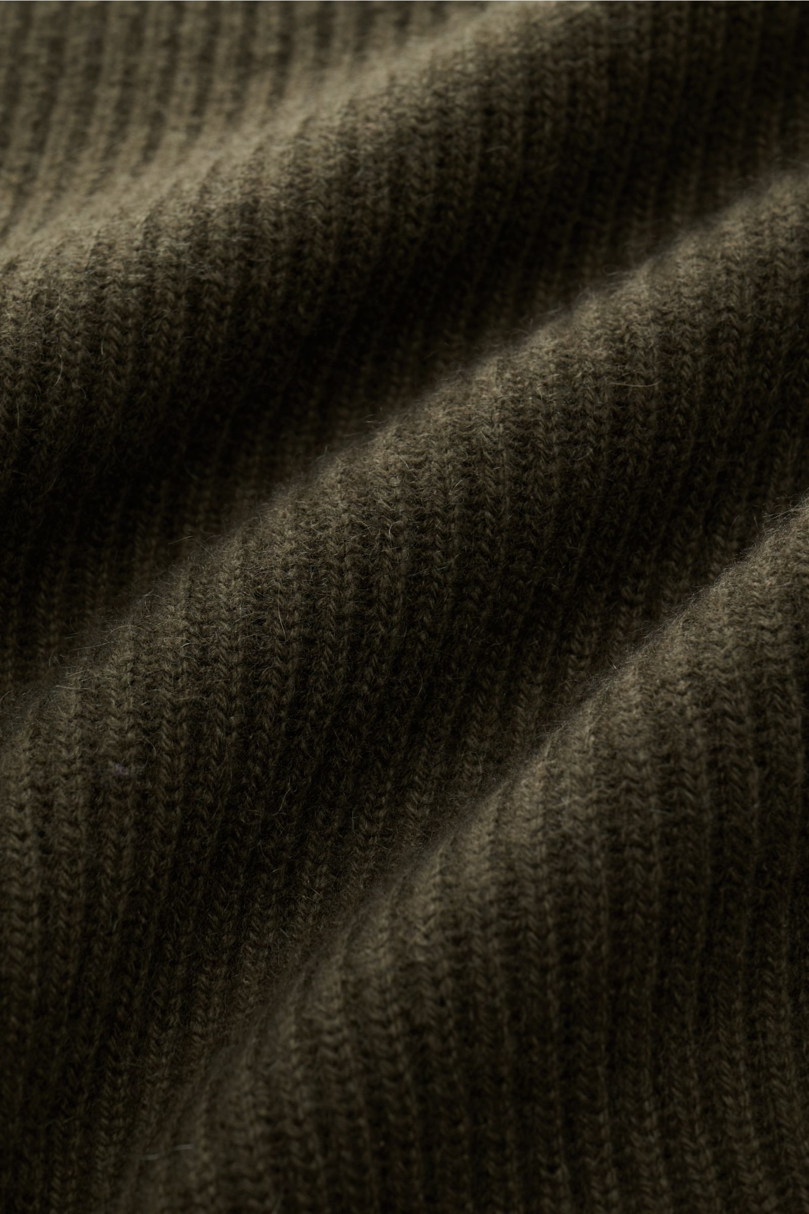 Nahaufnahme der olivgrünen von Braun Cashmere Strickjacke oliv in mittelfeinem Patentstrick mit weichem Griff und feiner Rippstruktur.