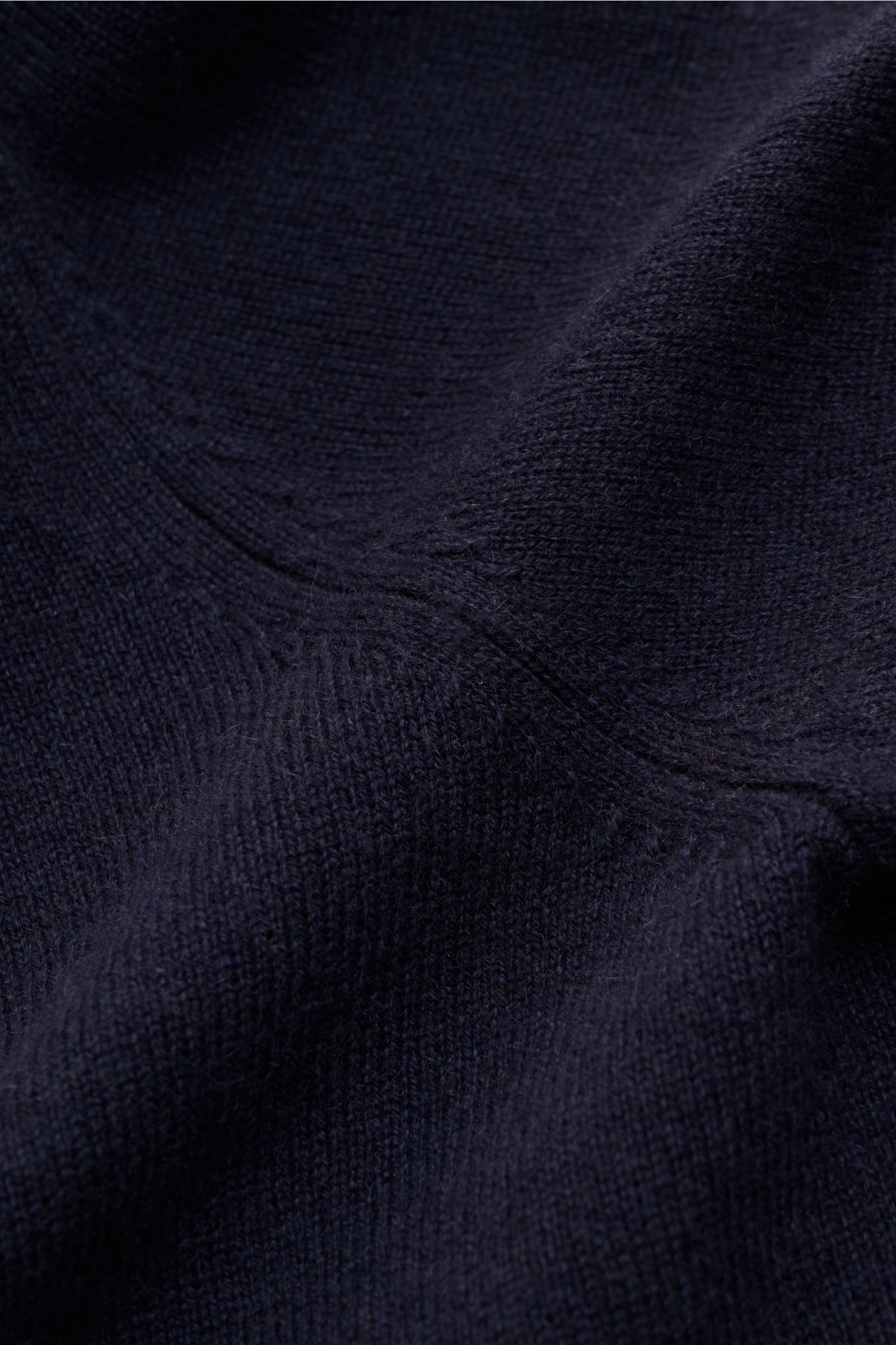 Nahaufnahme von feinem Strickbild und weichem Griff der von Braun Cashmere Strickjacke navy aus mongolischem Cashmere, perspektivisch fotografiert.