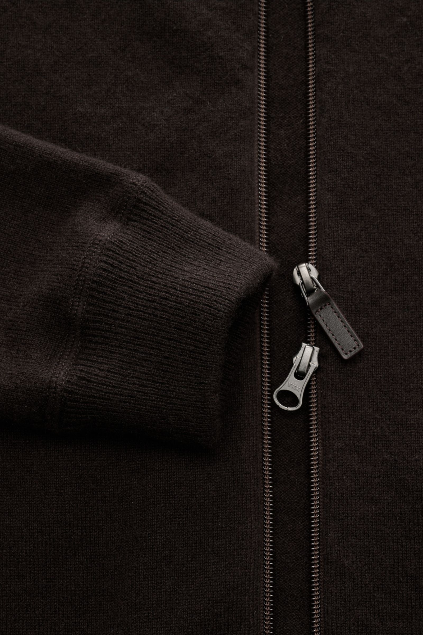 Nahaufnahme der von Braun Cashmere Strickjacke dunkelbraun mit weichem Rippbündchen, feinem Strickbild und zwei-Wege-Reißverschluss.
