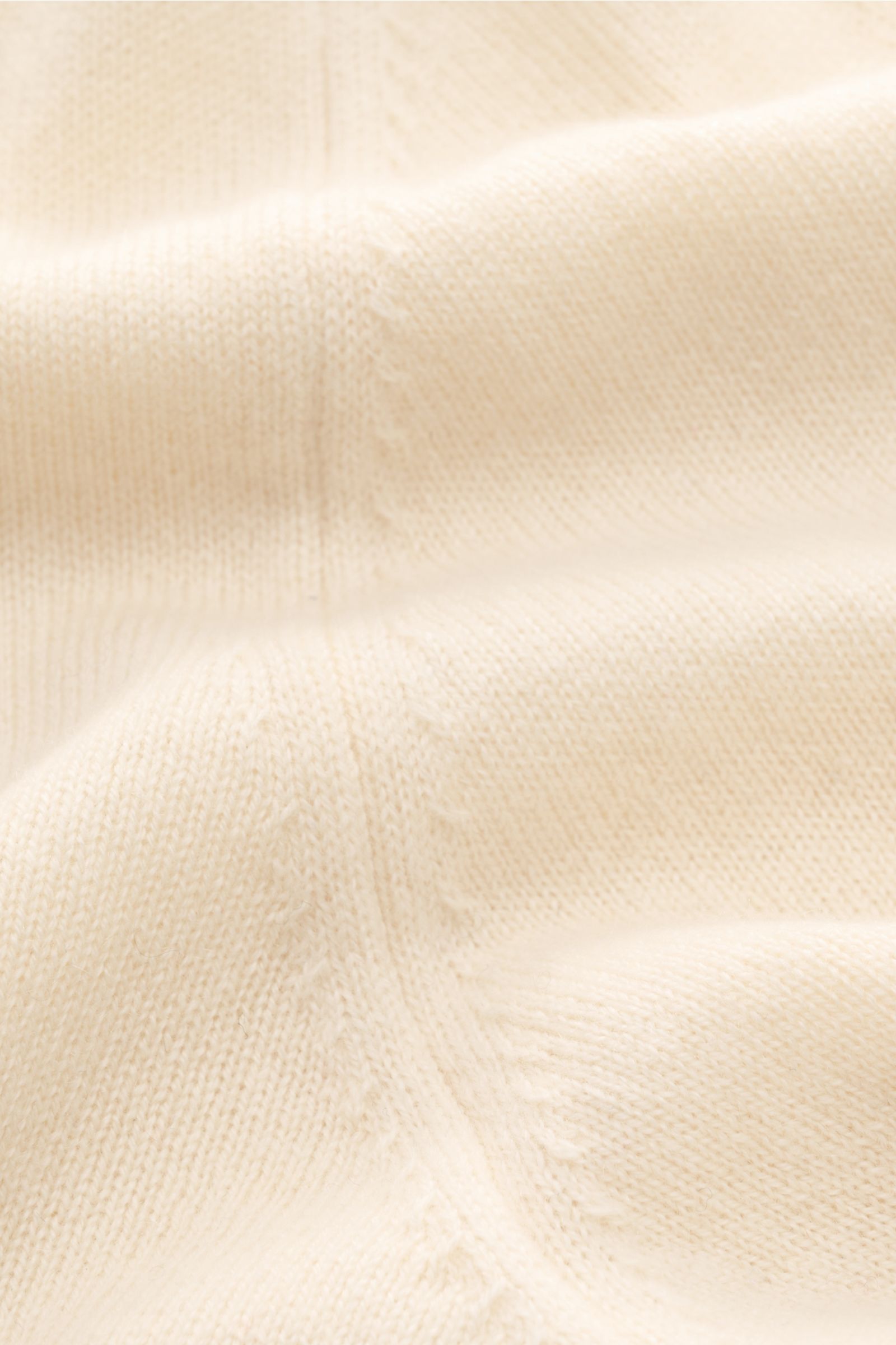 Nahaufnahme der von Braun Cashmere Strickjacke offwhite aus reinem mongolischem Cashmere mit feinem Strickbild und weichem Griff.