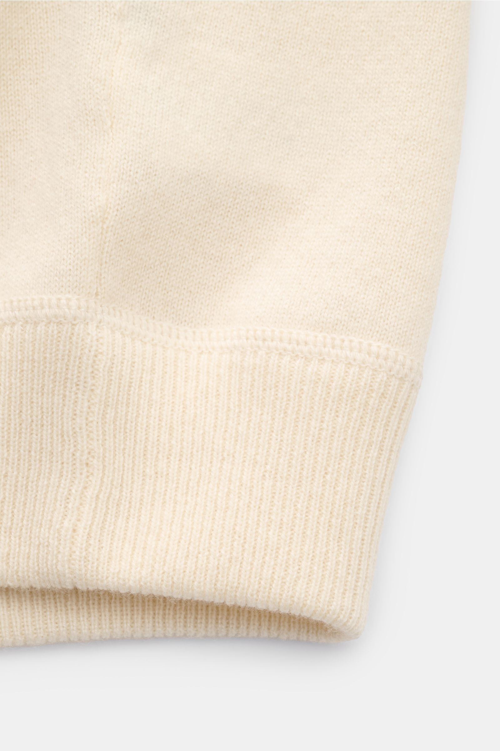 Nahaufnahme der von Braun Cashmere Strickjacke offwhite am Ärmelbündchen mit feinem Strickbild, weichem Griff und Rippbündchen.