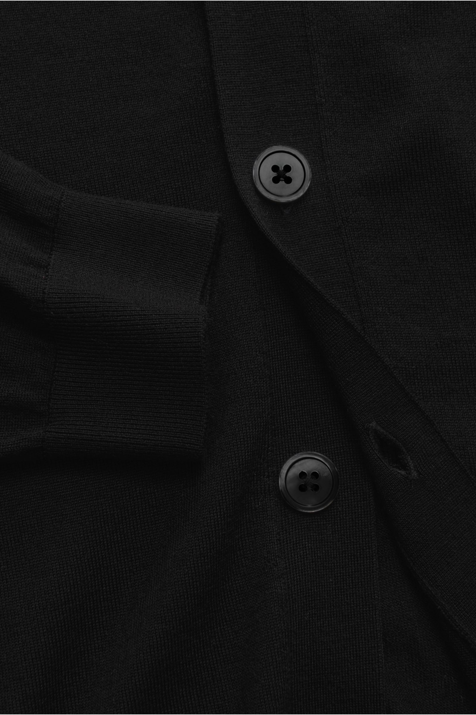 Nahaufnahme des von Braun Merino Cardigan schwarz aus reiner Merinowolle, Regular Fit, mit feinem Strickbild, Perlmuttknöpfen und elastischen Rippbündchen, von oben fotografiert.