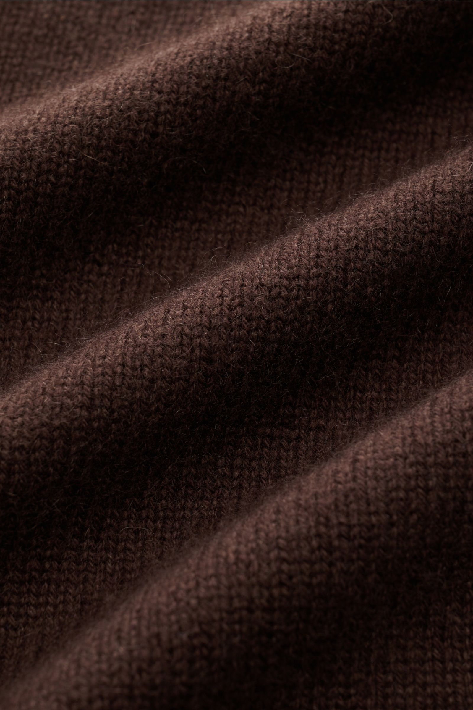 Soft Goat Cashmere Cardigan dunkelbraun close-up showing mid-fine knit texture and soft fibers, photographed from a top-down angle. Nachhaltig produziert und zertifiziert: Das junge Label SOFT GOAT macht es vor - mit ihrem super soften Cashmere Cardigan i