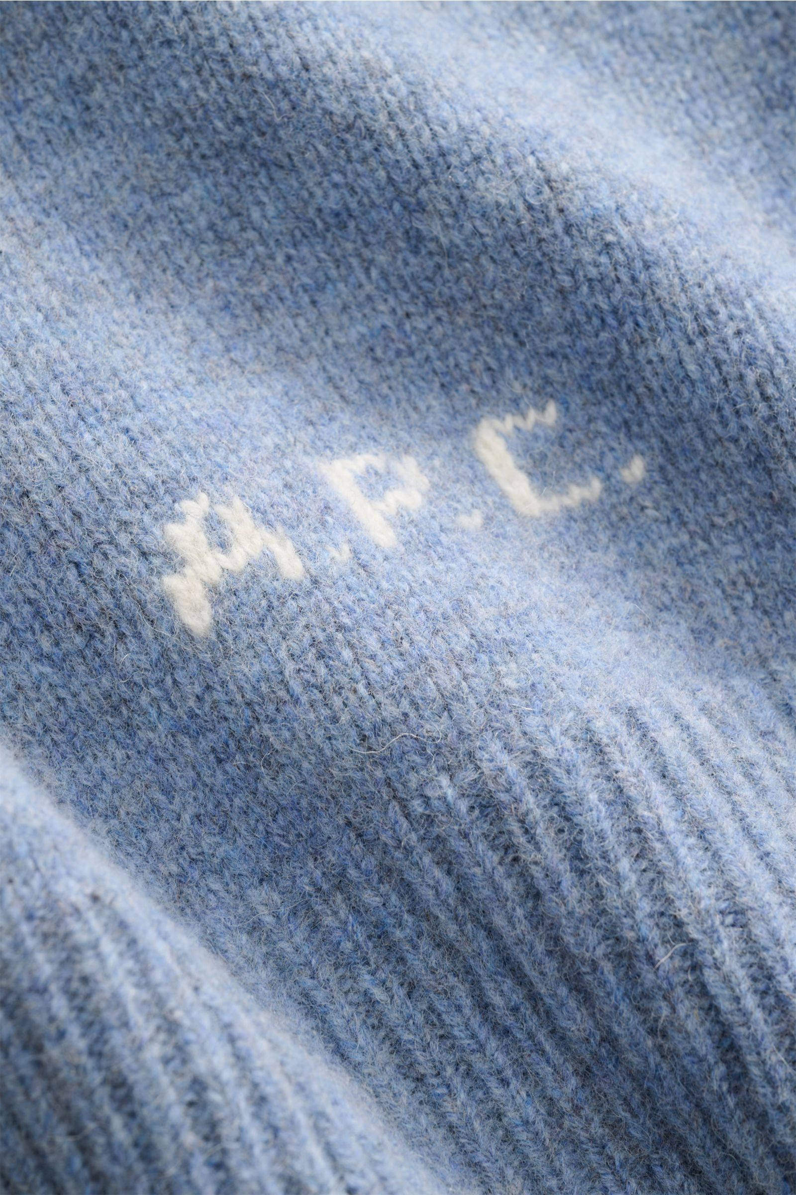 A.P.C. Cardigan 'Kevin' rauchblau meliert Detailaufnahme der reinen Wolle mit kontrastfarbenem Logo, weiche, leicht griffige Haptik, Nahaufnahme.