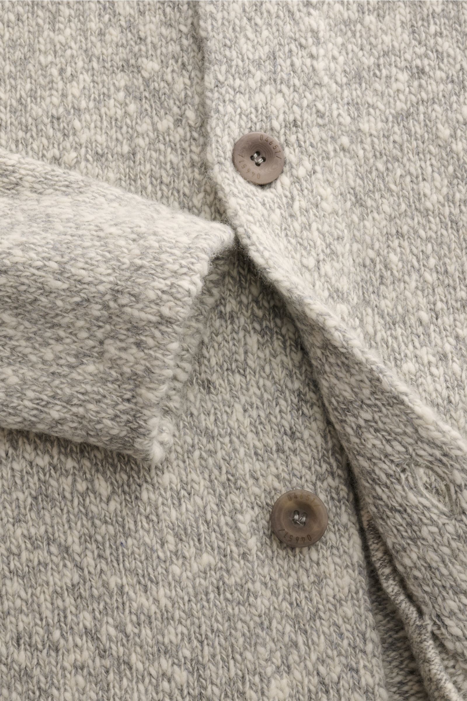 Close-up front view of 04651/ A trip in a bag Cardigan grau/offwhite meliert showing soft pure wool knit with voluminous texture, oversized fit, smooth button placket, shawl collar, and slanted front pockets. 

Warmes Layering-Essential: Der