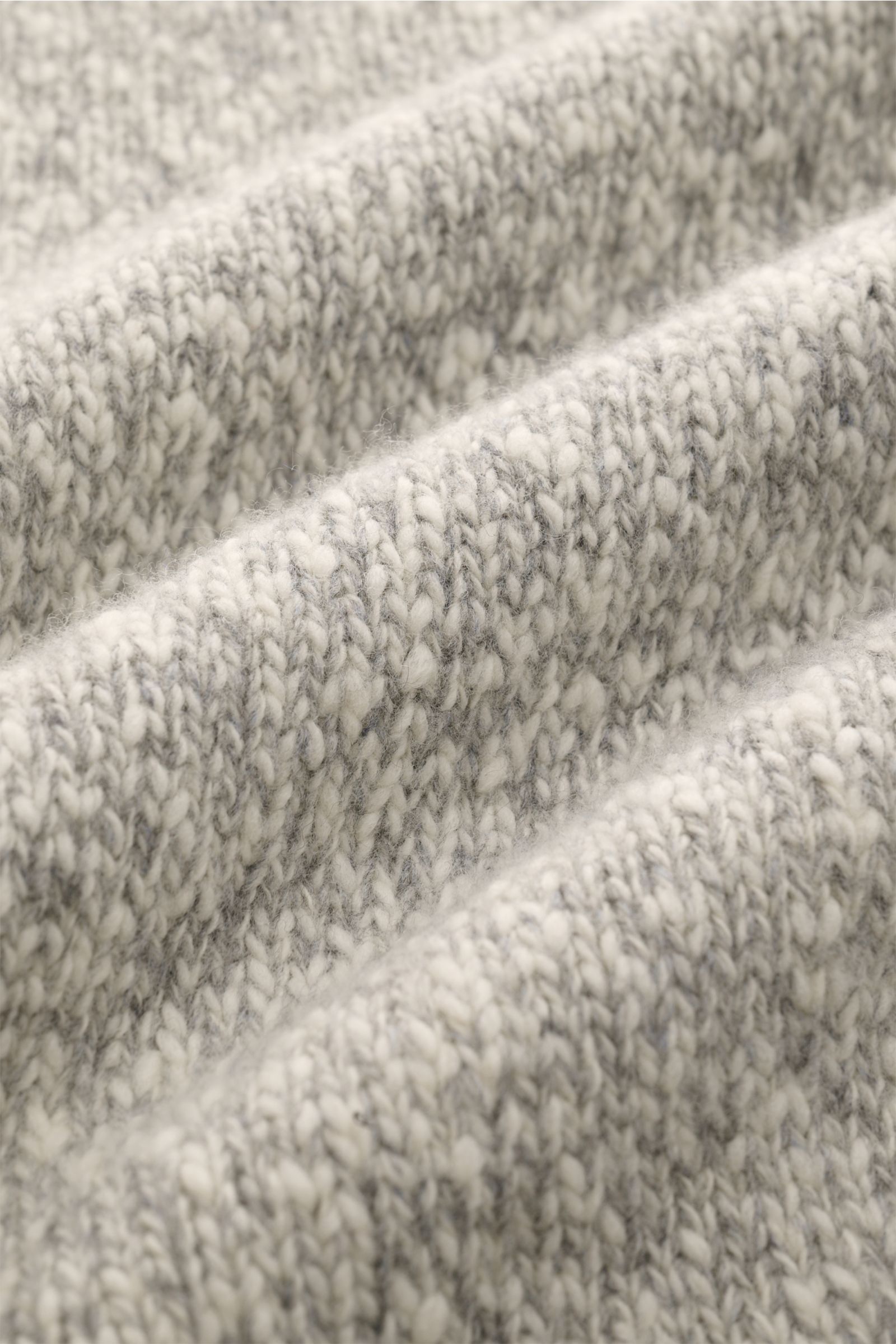 Close-up front view of 04651/ A trip in a bag Cardigan grau/offwhite meliert showing soft, voluminous knit texture and wool fibers.

Description: Warmes Layering-Essential: Der Cardigan aus der 'Look of the Games' Capsule von 04651/ A TRIP I