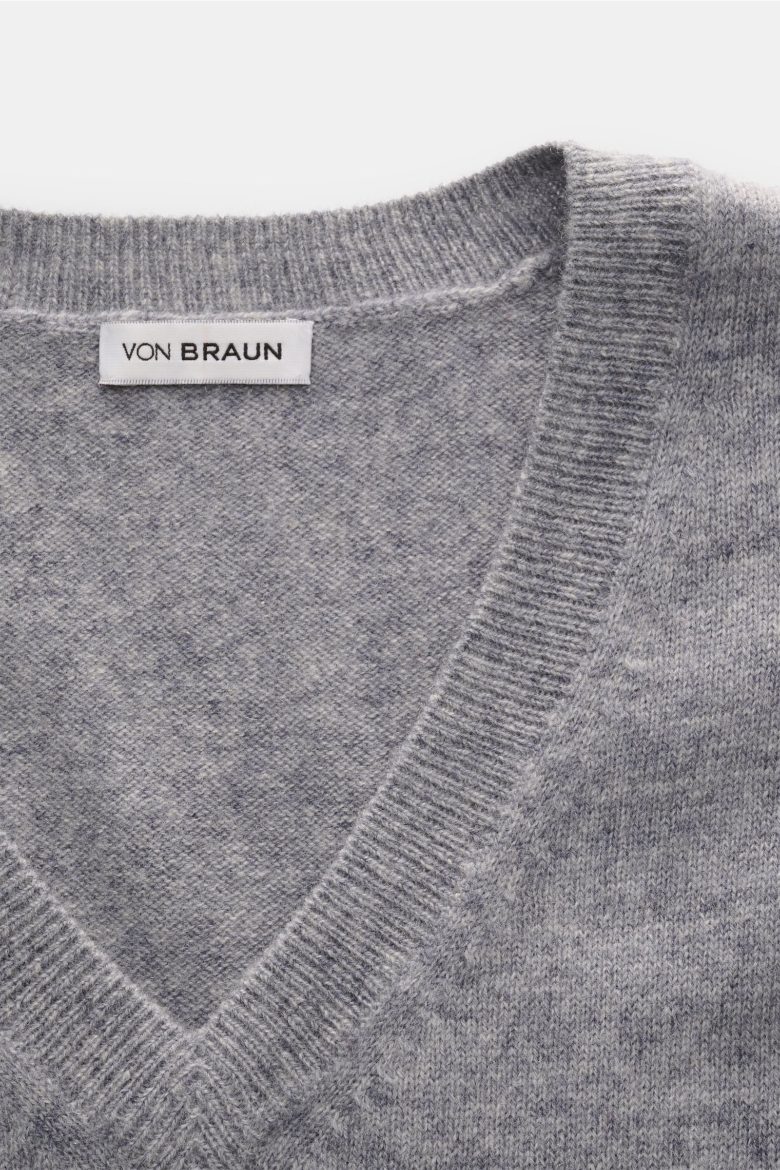 Close-up top view of von Braun Cashmere Pullunder grau meliert showing soft, fine-knit V-neck with elastic ribbed edges, pure cashmere.

Description: Geschmeidiges Layering-Piece: Der VON BRAUN Pullunder wurde aus reinem Cashmere gefertigt und lässt si