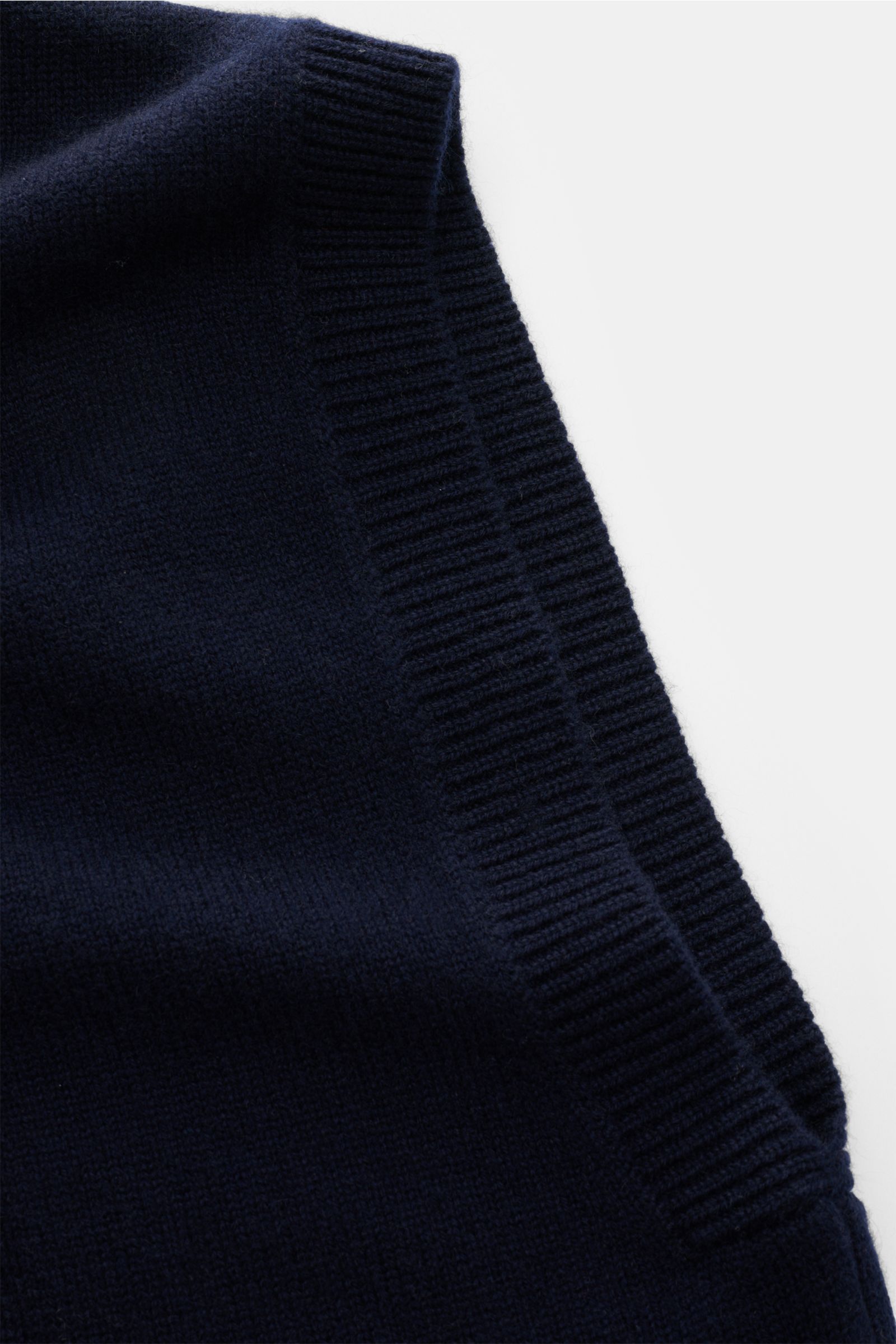 Close-up side view of the Lisa Yang Cashmere sweater vest 'Dennis' navy showing fine knit, rib knit hems, crew neck, slim fit, and soft pure cashmere fabric. The sweater vest 'Dennis' by LISA YANG combines luxurious cashmere with a modern design in a l