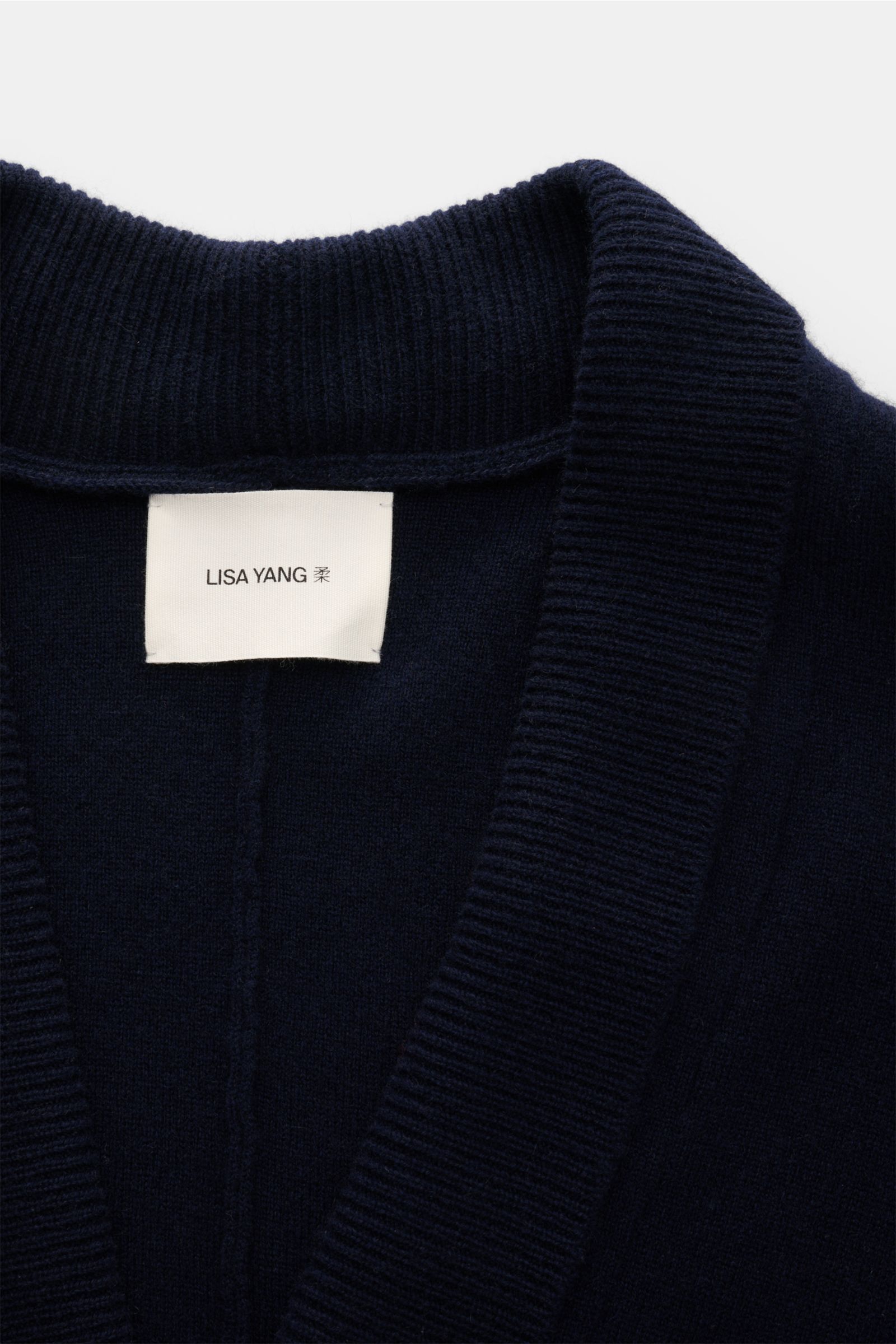 Close-up front view of Lisa Yang Cashmere cardigan 'Lance' navy showing shawl collar in rib knit and label.

Contemporary design by LISA YANG: With this straight-cut cardigan in a heavy fabric made from pure cashmere, you can style clean minimalist loo