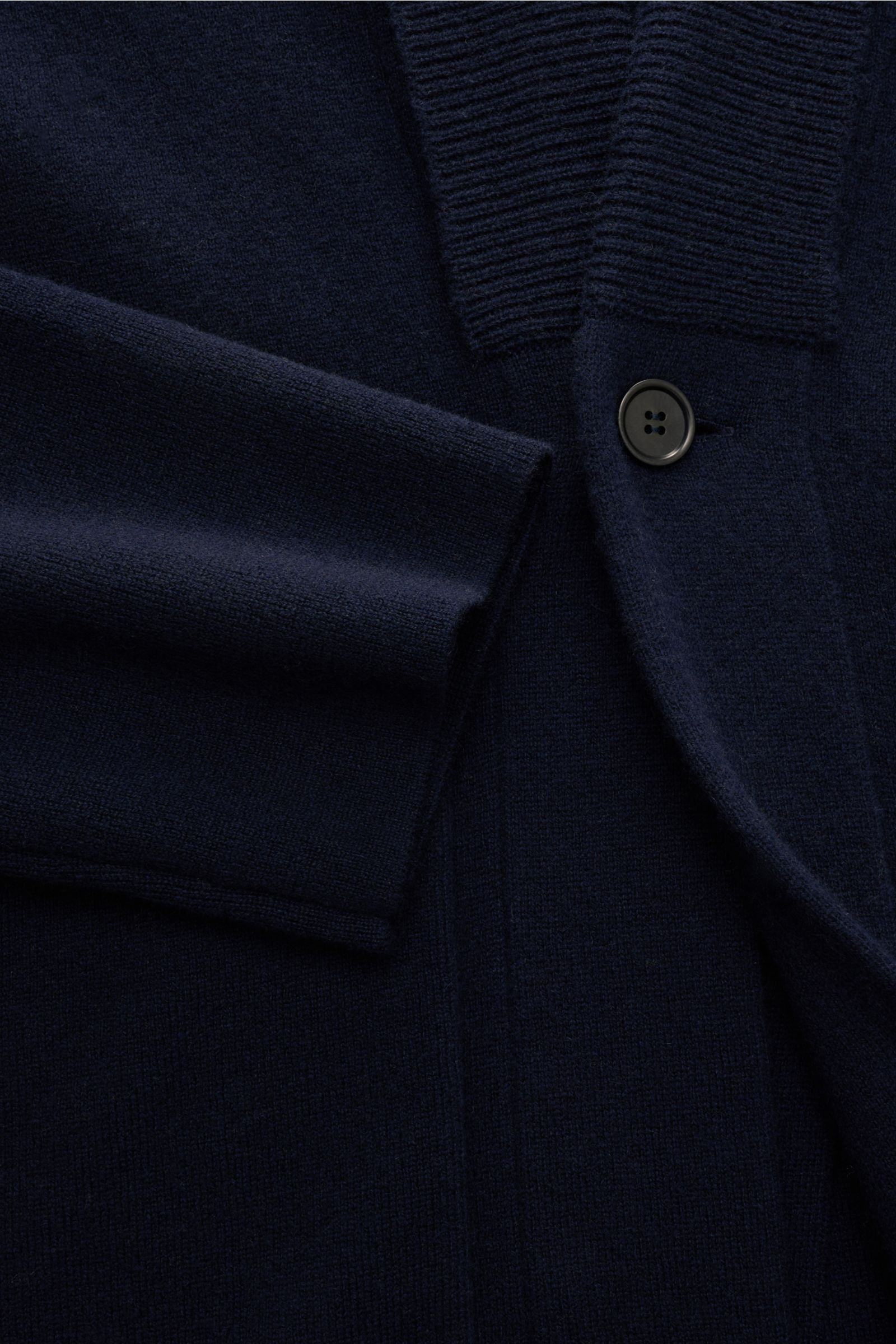 Close-up front view of the Lisa Yang Cashmere cardigan 'Lance' navy showing the medium-fine knit, shawl collar, one button, large patch hip pockets, ribbed bands, and soft pure cashmere fabric. Contemporary design by LISA YANG: With this straight-cut card