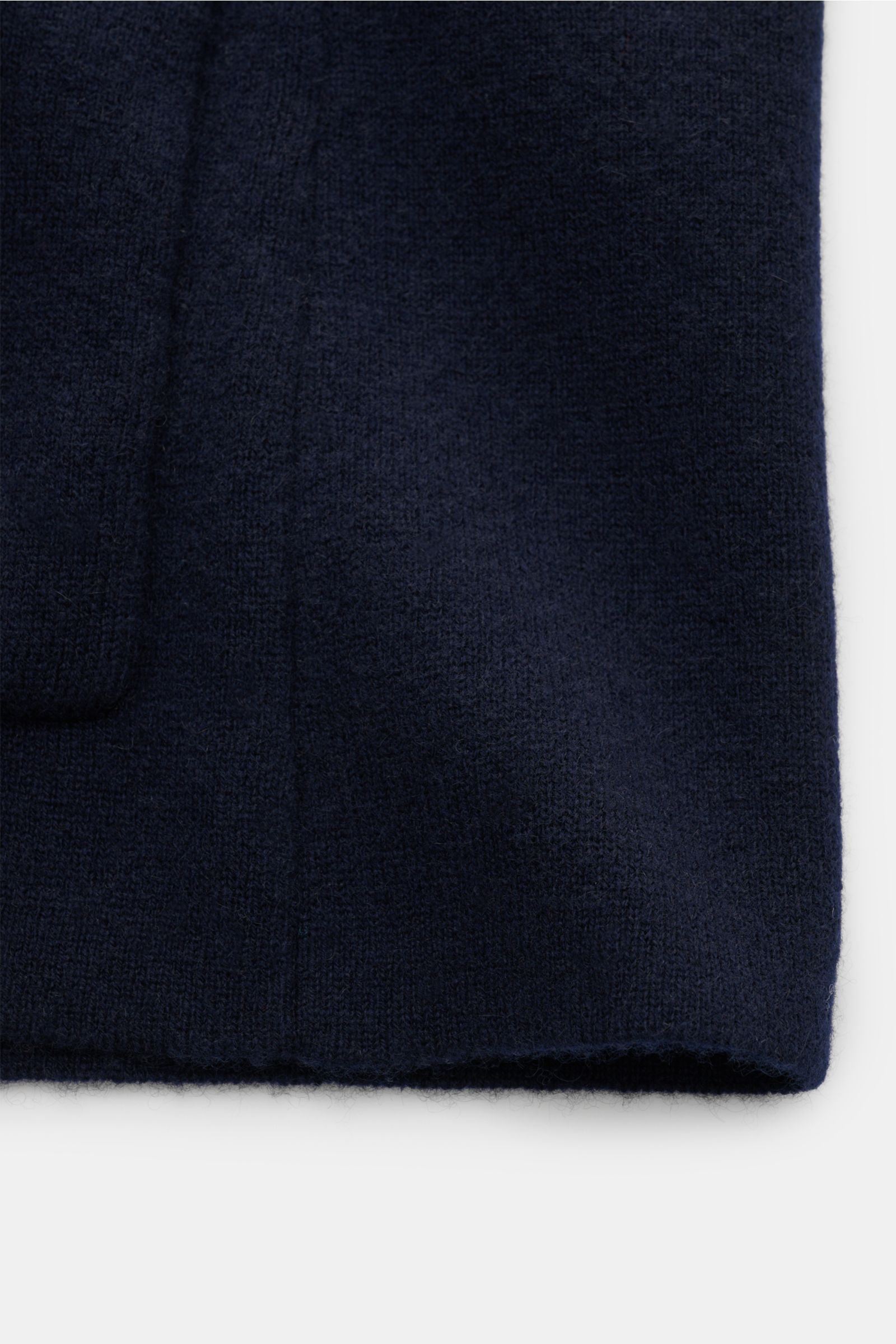 Close-up view of the lower front section of the Lisa Yang Cashmere cardigan 'Lance' navy, showing the soft, medium-fine pure cashmere knit fabric with ribbed bands and a large patch hip pocket. Contemporary design by LISA YANG: With this straight-cut card