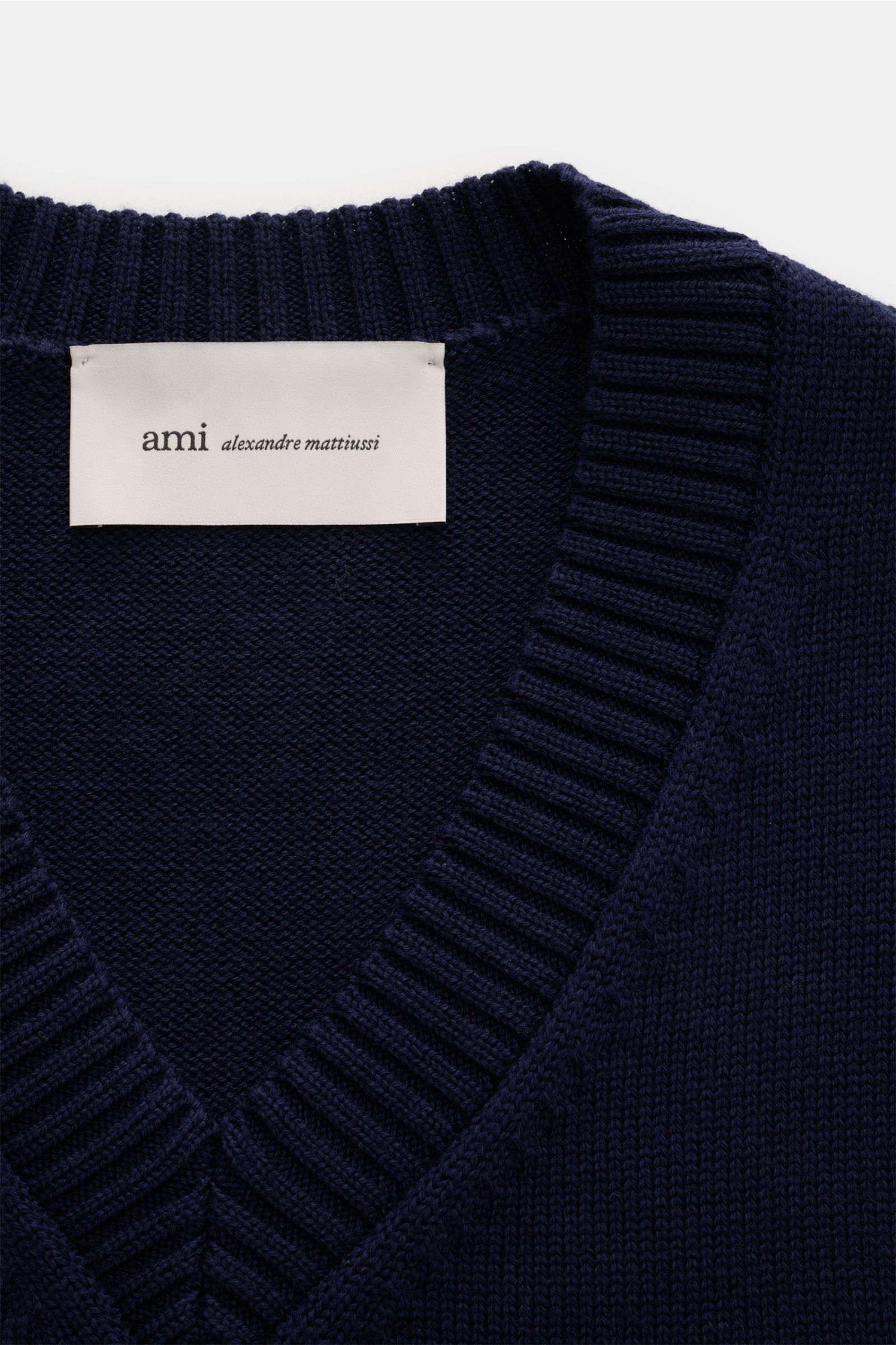 Close-up front view of the Ami Paris V-Neck Pullunder navy showing knit texture, ribbed V-neck collar, and brand label.

Layering-Piece von AMI PARIS: Der ikonische Pullunder mit V-Neck und typisch abgestepptem 'Ami'-Logo wurde aus Wolle und Baumwolle 
