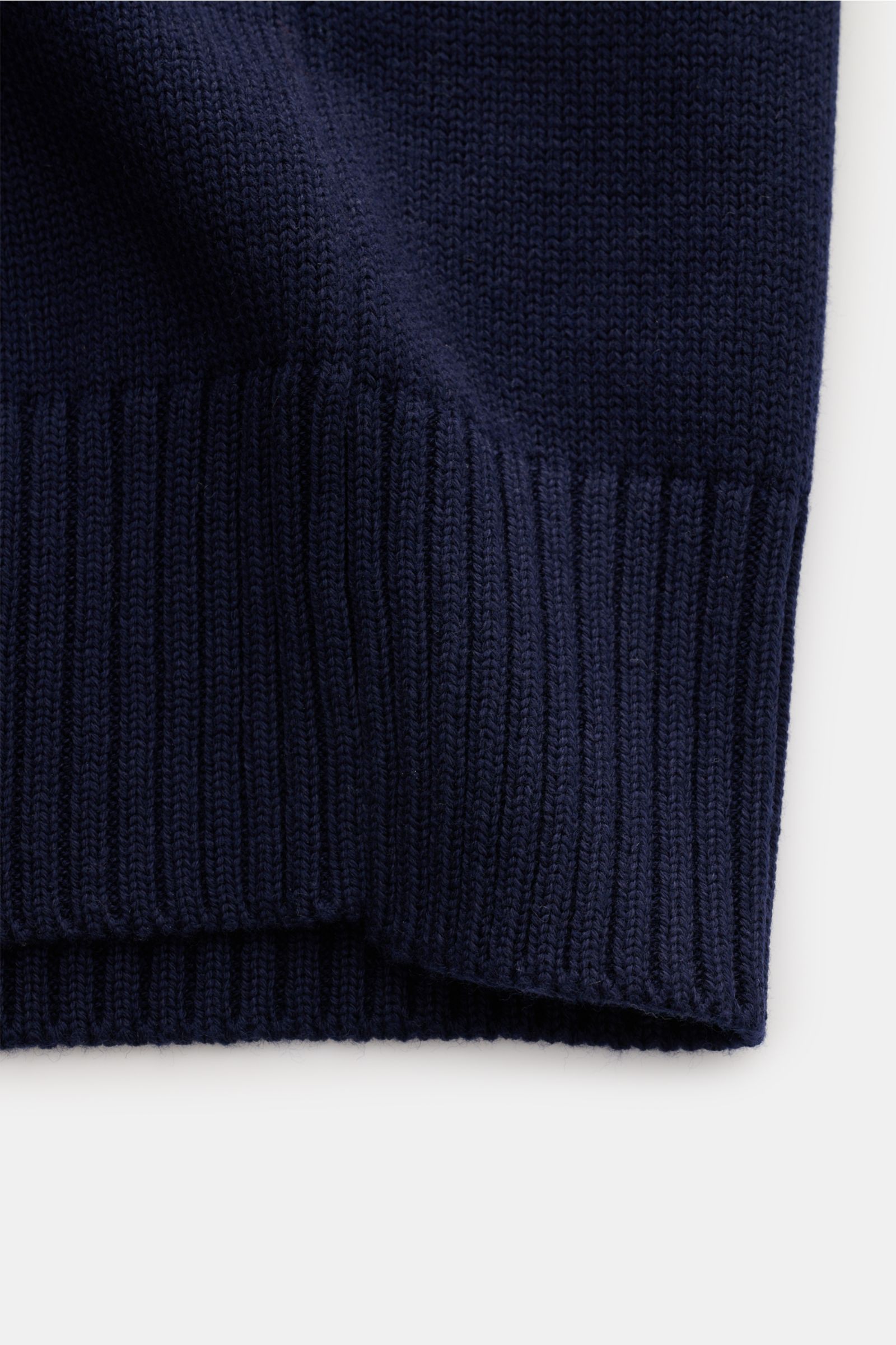 Close-up of the lower section of the Ami Paris V-Neck Pullunder navy, showing the ribbed hem in a soft wool and cotton knit, photographed from above. Layering-Piece von AMI PARIS: Der ikonische Pullunder mit V-Neck und typisch abgestepptem 'Ami'-Logo w