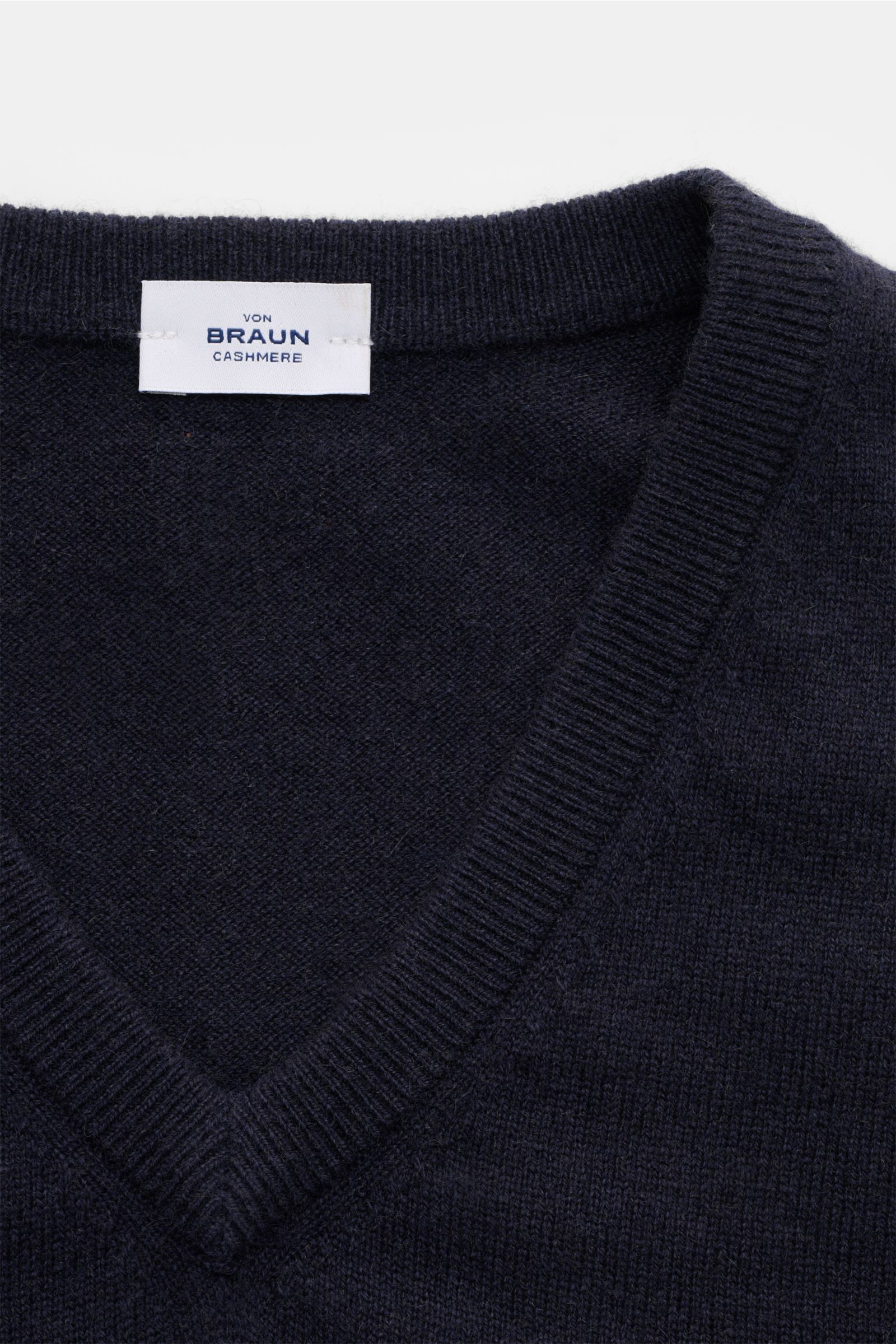 Close-up front-top view of von Braun Cashmere Pullunder navy showing fine knit texture and ribbed V-neck collar, made from pure Mongolian cashmere.

Geschmeidiges Layering-Piece: Der VON BRAUN Pullunder wurde aus reinem Cashmere gefertigt, der aus der 
