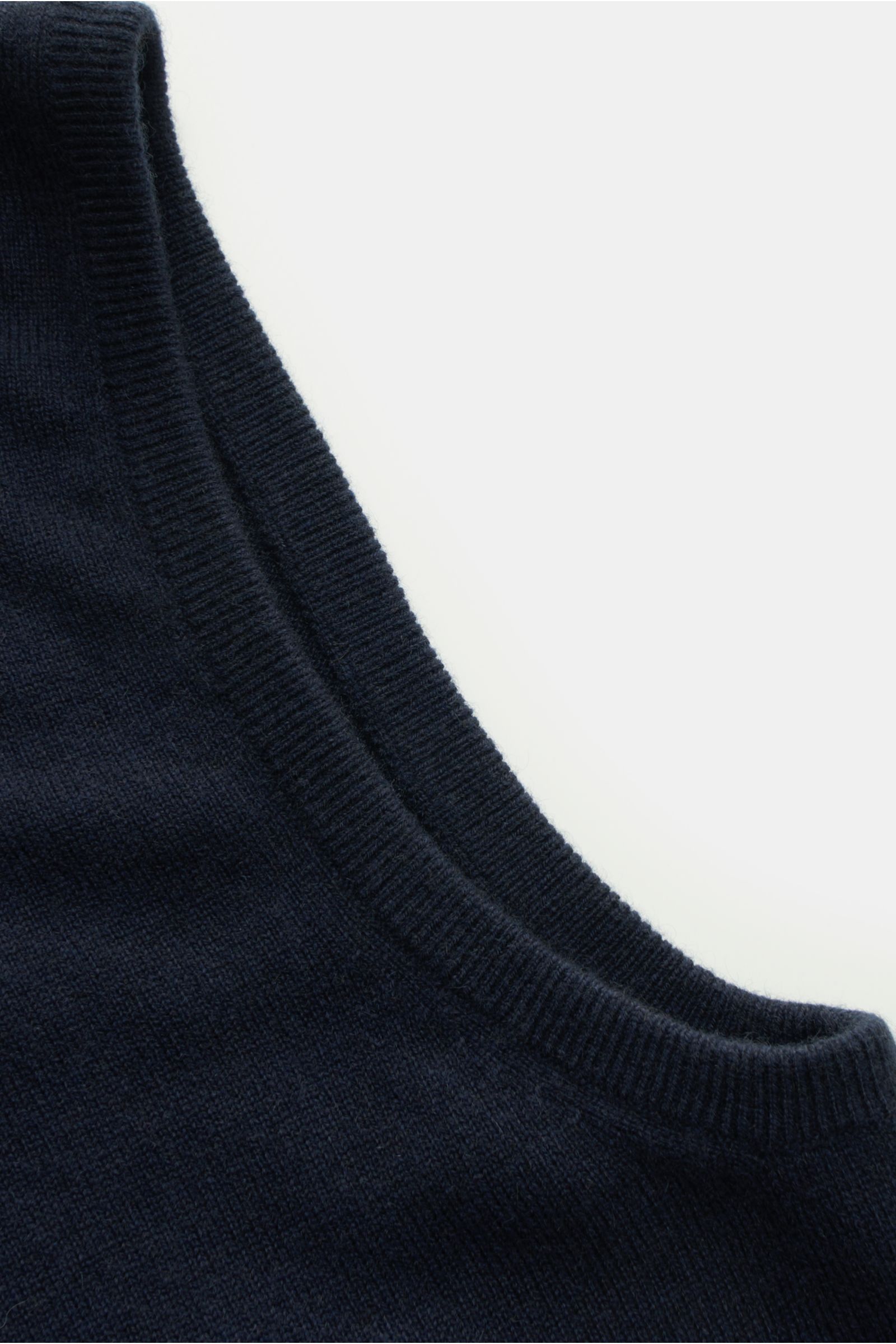 Close-up top-down view of the von Braun Cashmere Pullunder navy showing its fine knit texture and ribbed edges, made from pure Mongolian cashmere, featuring a very soft touch, slim fit, and elastic ribbed cuffs. 

Description: Geschmeidiges Layering-Pi