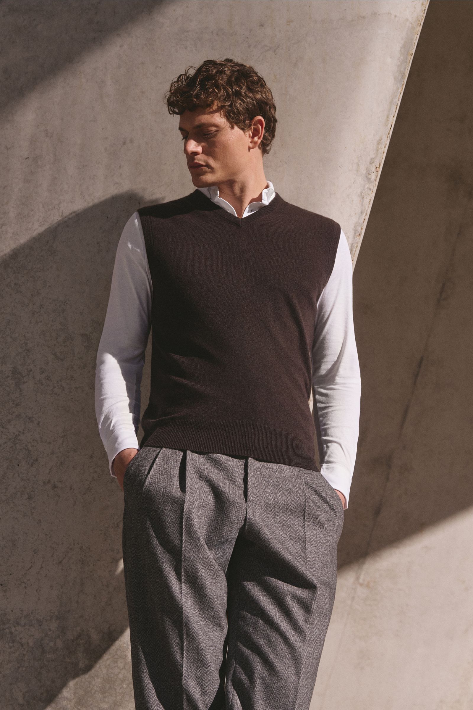 Front view of a man wearing the von Braun Cashmere sweater vest dark brown over a white shirt and grey trousers, showcasing a slim fit with elasticated ribbed bands.

Soft layering piece: This VON BRAUN sweater vest is made of pure Mongolian cashmere t