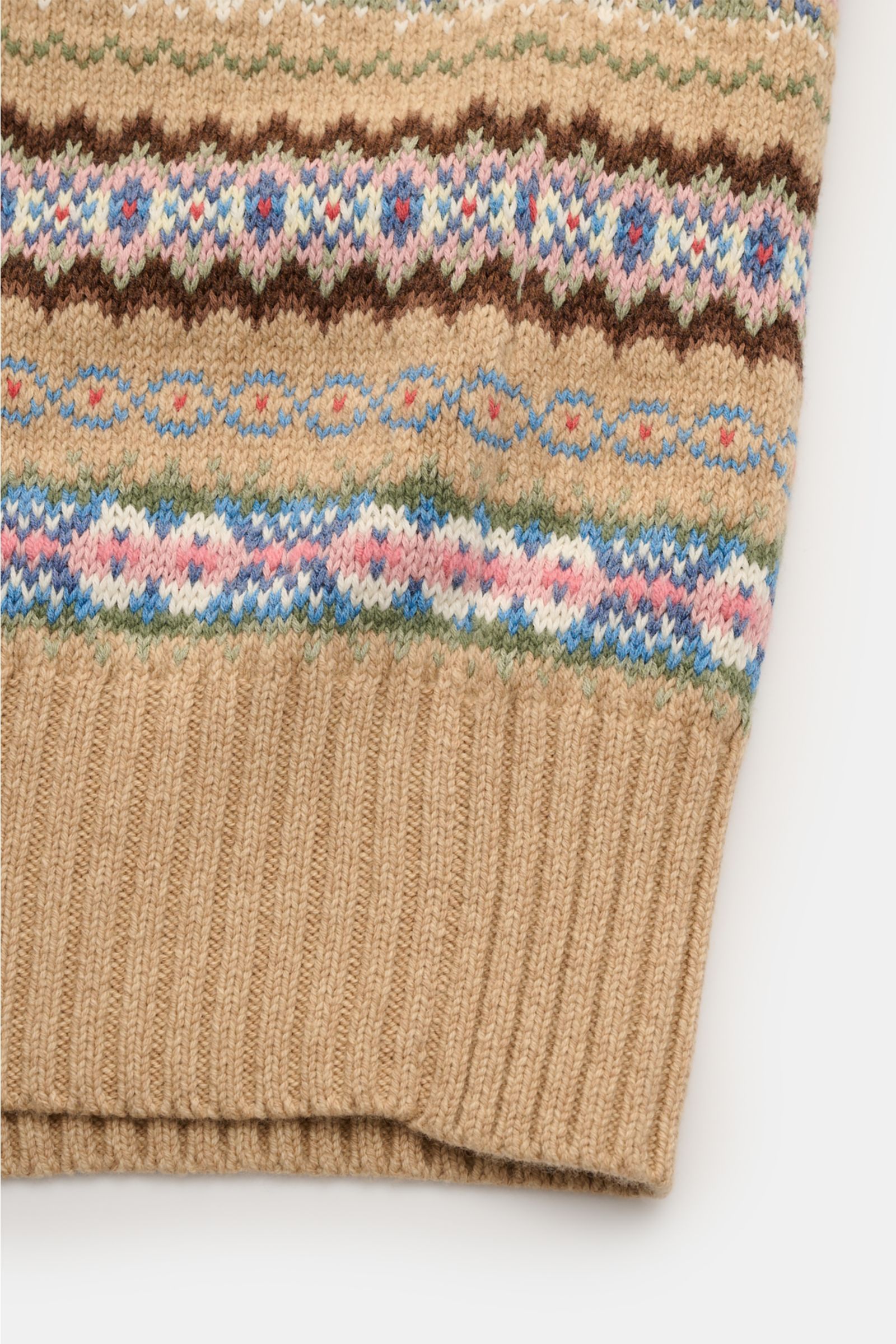 Nahaufnahme aus schräger Perspektive eines Polo Ralph Lauren Pullunders beige gemustert mit mittelfeinem Strickbild, V-Ausschnitt, weichem Griff und elastischen Rippbündchen aus Baumwolle und Wolle.