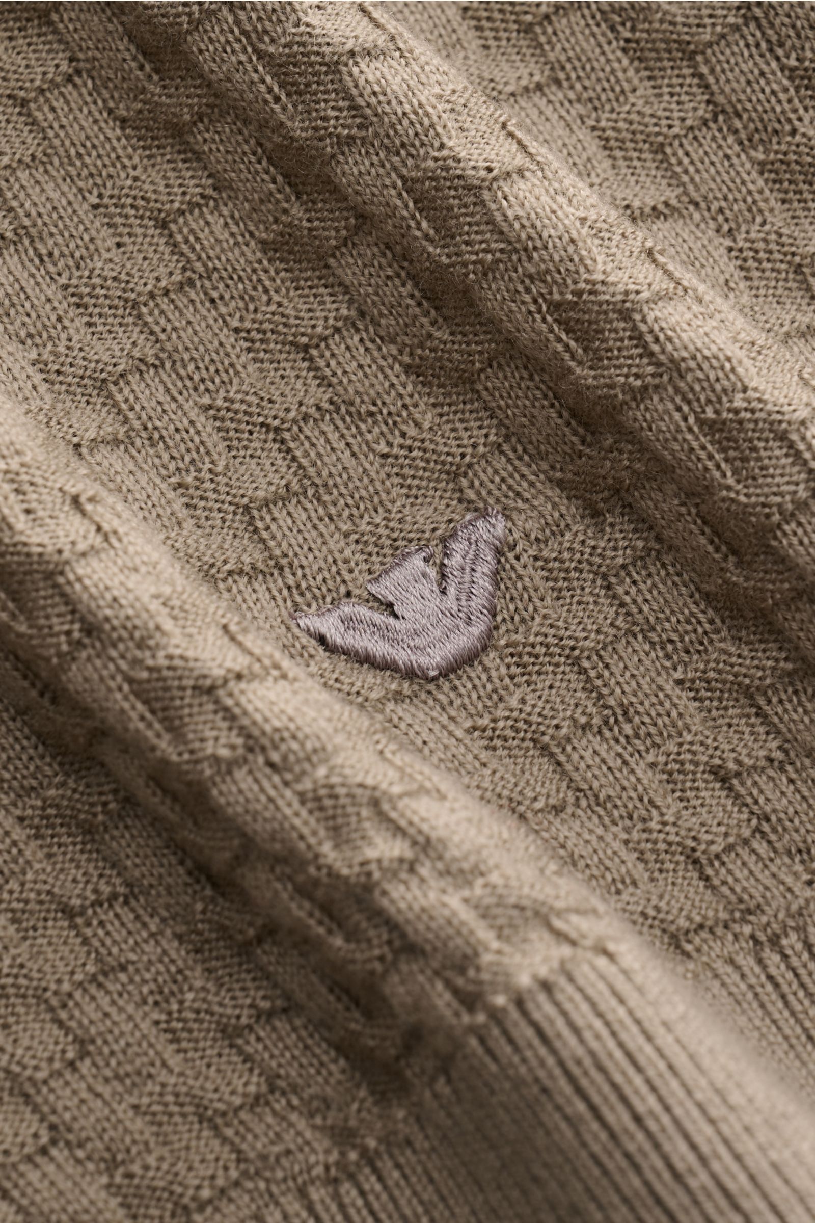 Close-up front view of Emporio Armani Crew neck jumper beige showing fine textured knit, ribbed bands, and embroidered logo.

Versatile companion: This lightweight short sleeve jumper in pure virgin wool by EMPORIO ARMANI has a subtle textured pattern 