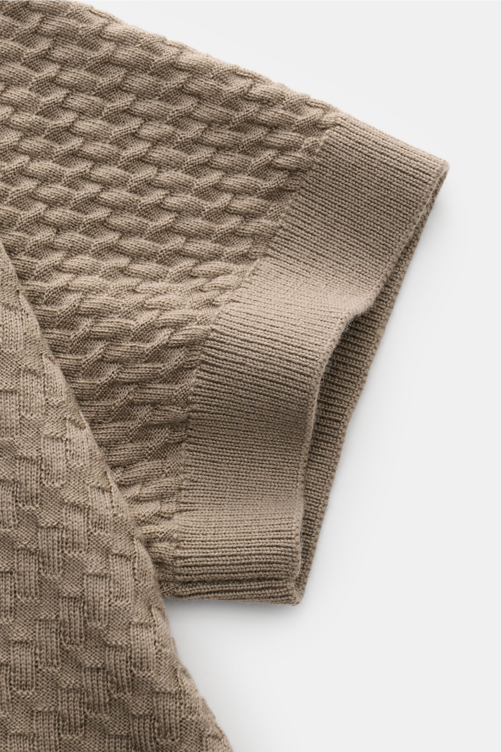 Close-up of the sleeve and textured knit pattern on the Emporio Armani Crew neck jumper beige, photographed from above.

Versatile companion: This lightweight short sleeve jumper in pure virgin wool by EMPORIO ARMANI has a subtle textured pattern and i