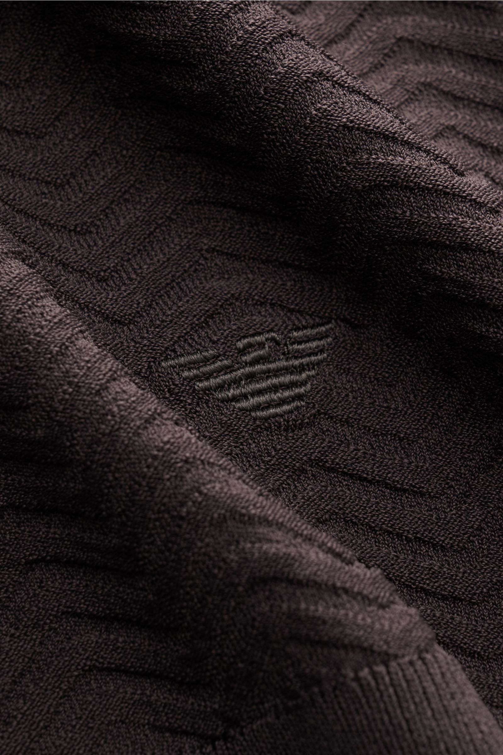 Close-up view of the Emporio Armani Kurzarmpullover dunkelgrau showing its elegant textured knit pattern, slim fit, round neckline, comfortable ribbed cuffs, and subtle logo-stitching. Facettenreicher Hingucker: Der Kurzarmpullover von EMPORIO ARMANI über