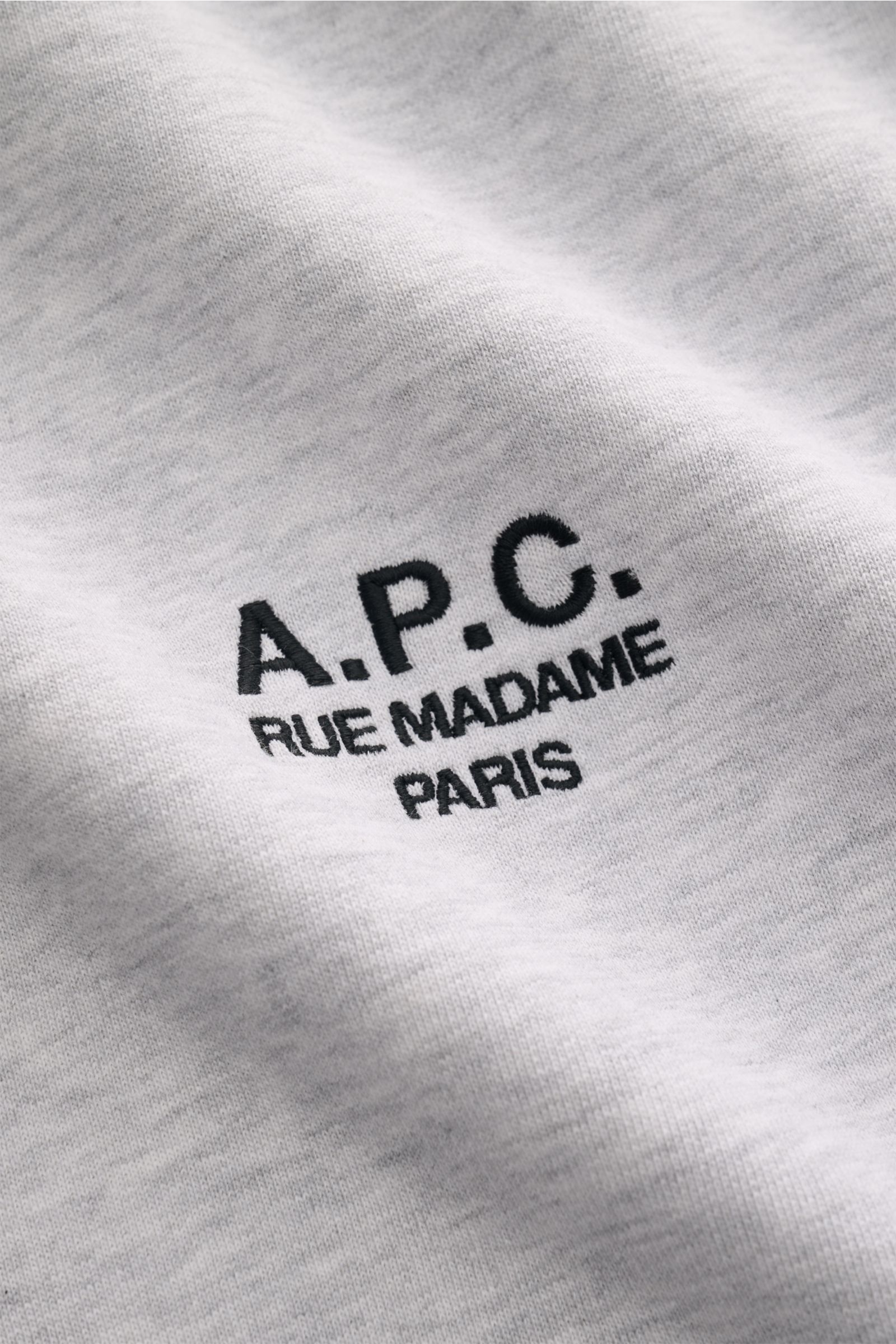 A.P.C. Rundhals-Sweatshirt 'Standard Rue Madame' hellgrau meliert, Nahaufnahme des farblich abgesetzten Logo-Stitchings auf weichem Baumwollstoff.