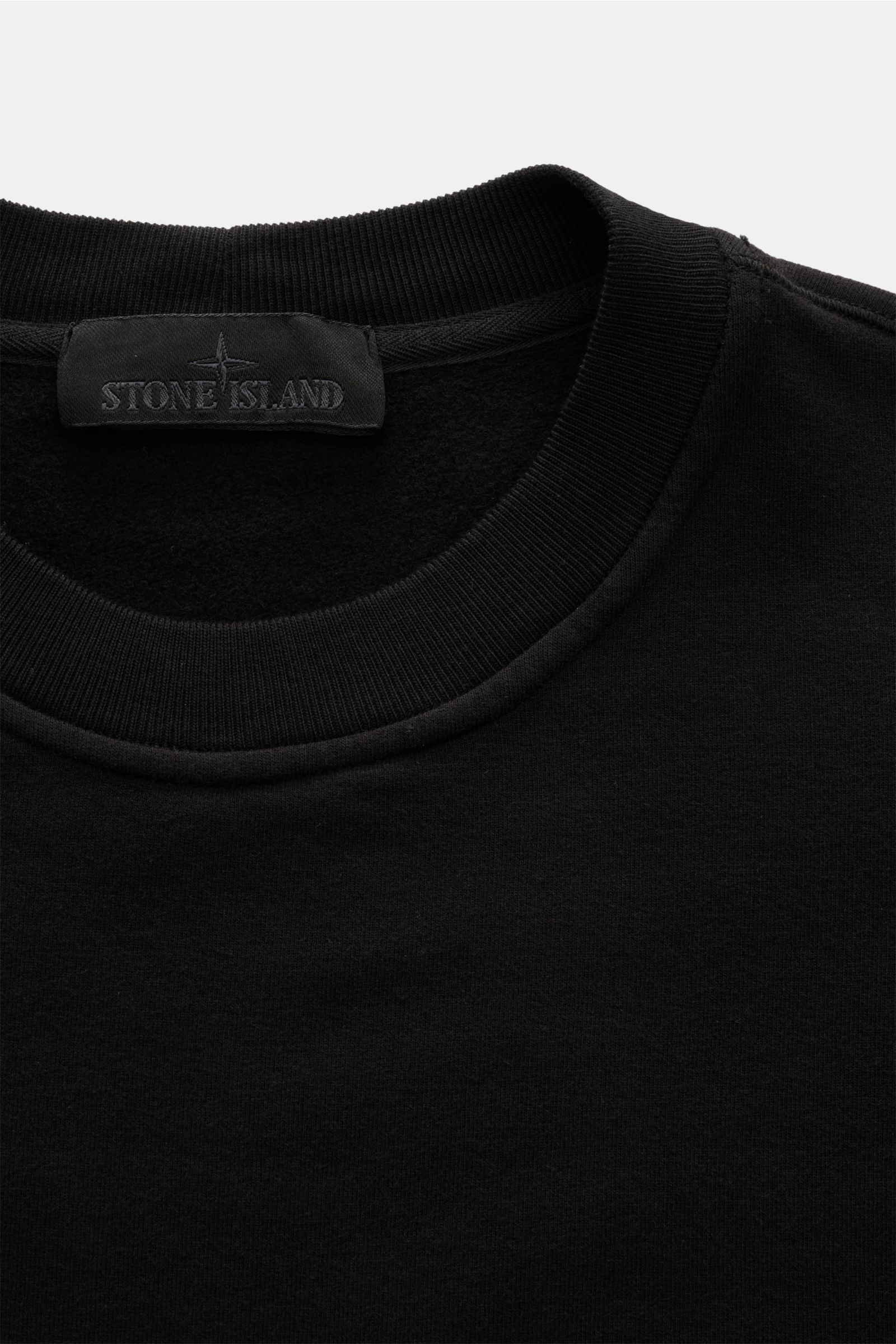 Stone Island Rundhals-Sweatshirt 'Ghost Piece' schwarz, nahes Detail von Rundhalsausschnitt, soft angeraut innen, tonales Kompass-Badge.