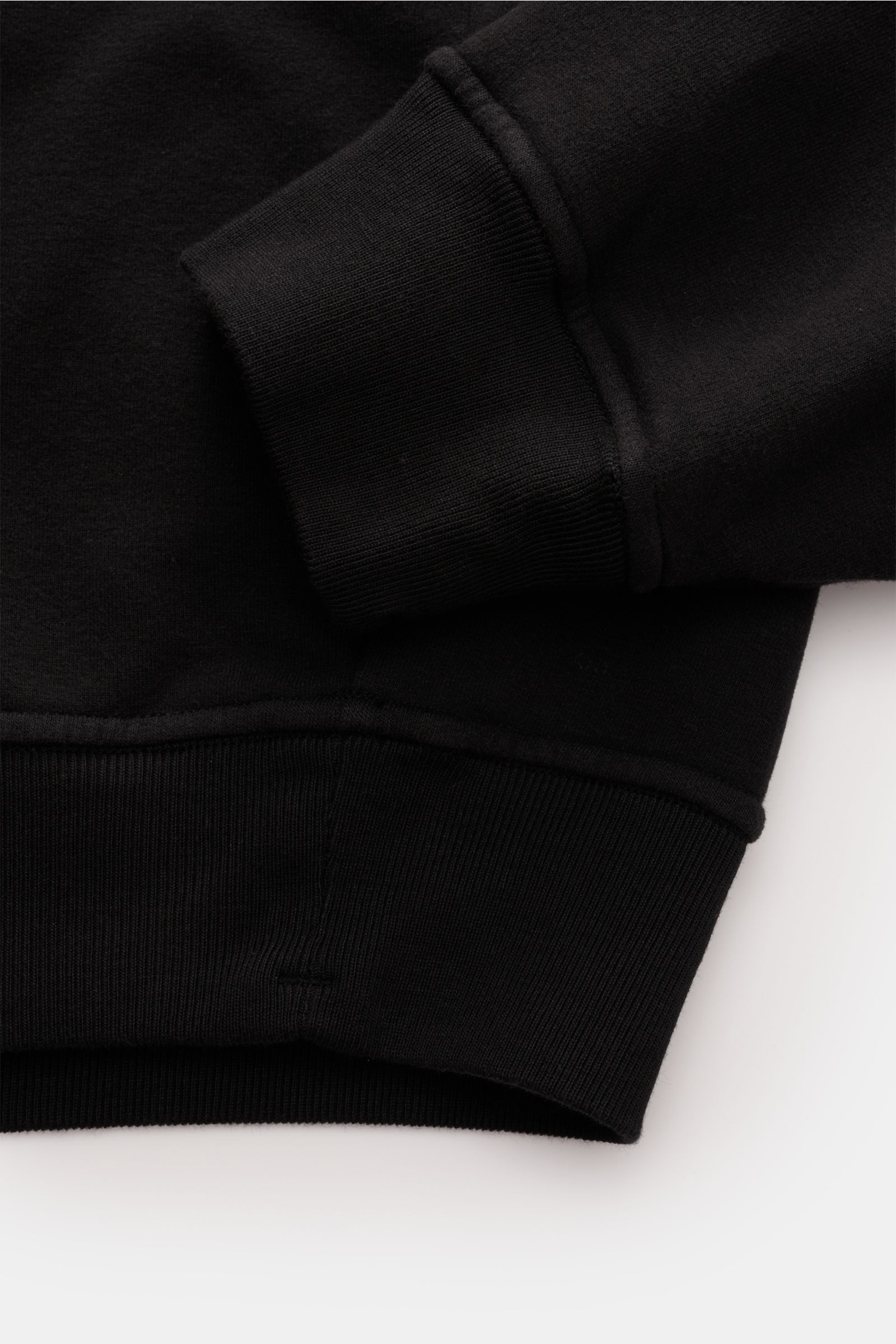 Stone Island Rundhals-Sweatshirt 'Ghost Piece' schwarz, Detailaufnahme von Ärmel und Bündchen, weicher Baumwoll-Sweat mit tonalem Kompass-Badge.