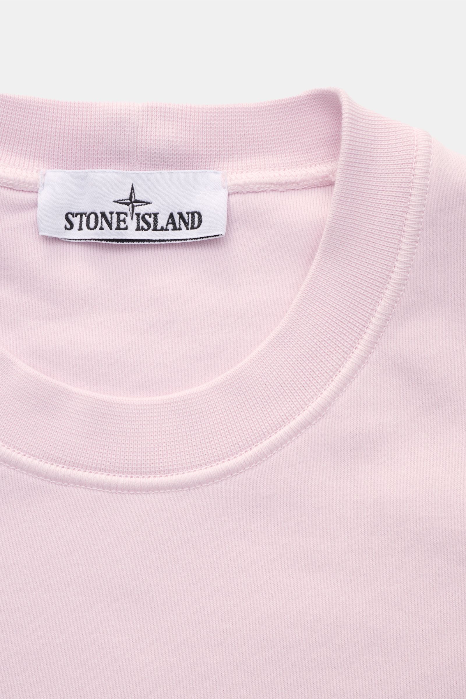 Stone Island Rundhals-Sweatshirt rosé, Nahaufnahme von oben, Sweat aus reiner Baumwolle, weicher Griff, markante Naht, garment dyed, Slim Fit, Rundhalsausschnitt, Kompass-Badge, Rippbündchen.