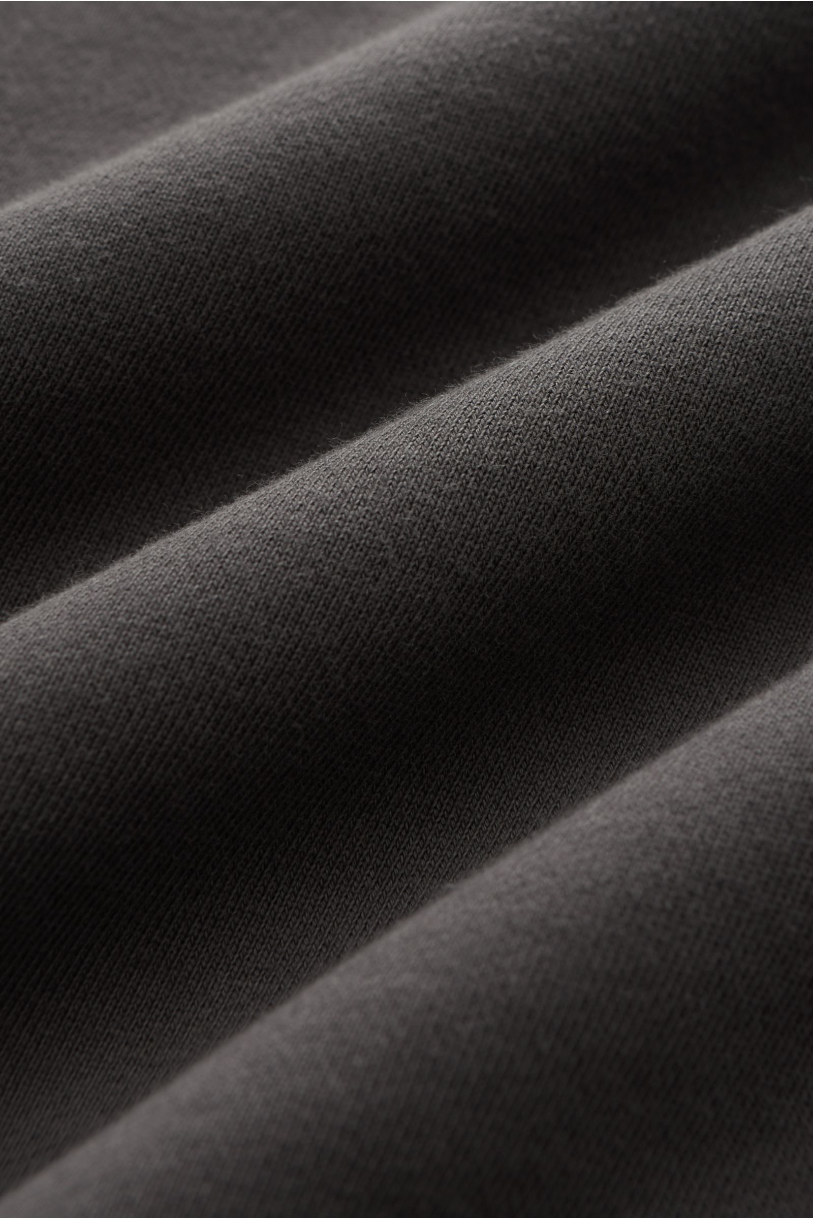 Stone Island Rundhals-Sweatshirt dunkelgrau, Nahaufnahme Stoffstruktur, reine Baumwolle, weicher Griff, markante Naht, garment dyed, Slim Fit, Rundhalsausschnitt, Kompass-Badge, Sweat Innenseite, komfortable Rippbündchen.