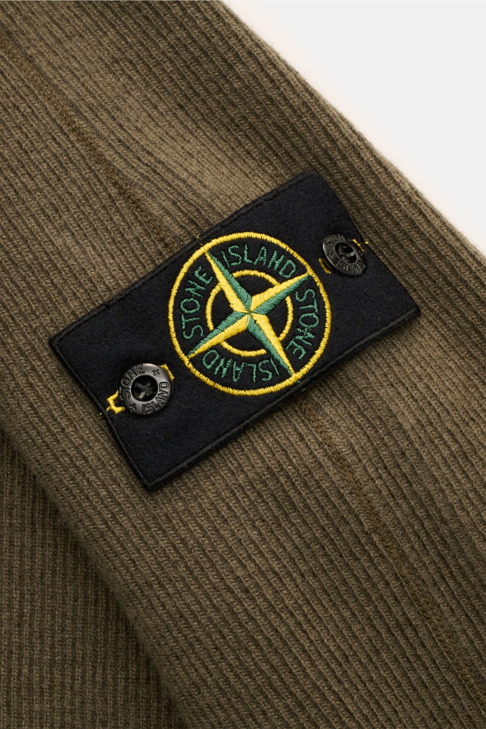 Stone Island Rundhalspullover 'Ribbed Wool Nylon' oliv, Nahaufnahme Ärmel mit Kompass-Badge, feiner Rippstrick aus Wolle-Nylon-Mix.