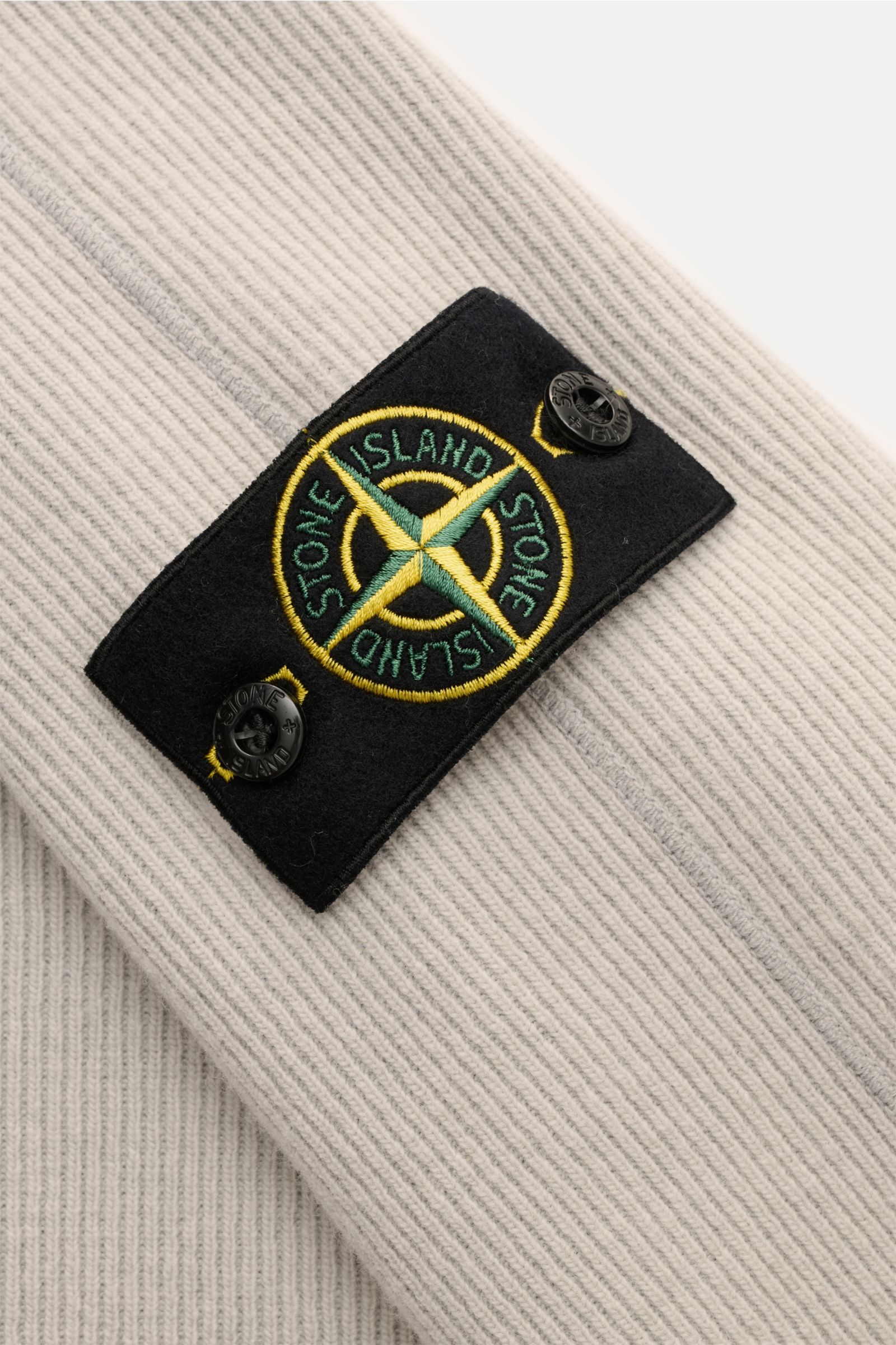 Stone Island Rundhalspullover 'Ribbed Wool Nylon' grau in Nahaufnahme, Rippstrick und Kompass-Badge am Ärmel sichtbar.