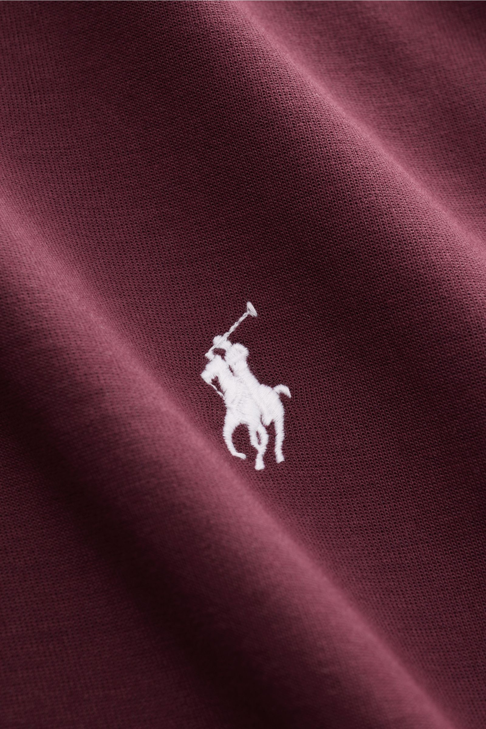 Nahaufnahme des Polo Ralph Lauren Sweat-Troyer bordeaux aus weichem Jersey, mit Polo-Reiter-Stitching, fotografiert von schräg oben.