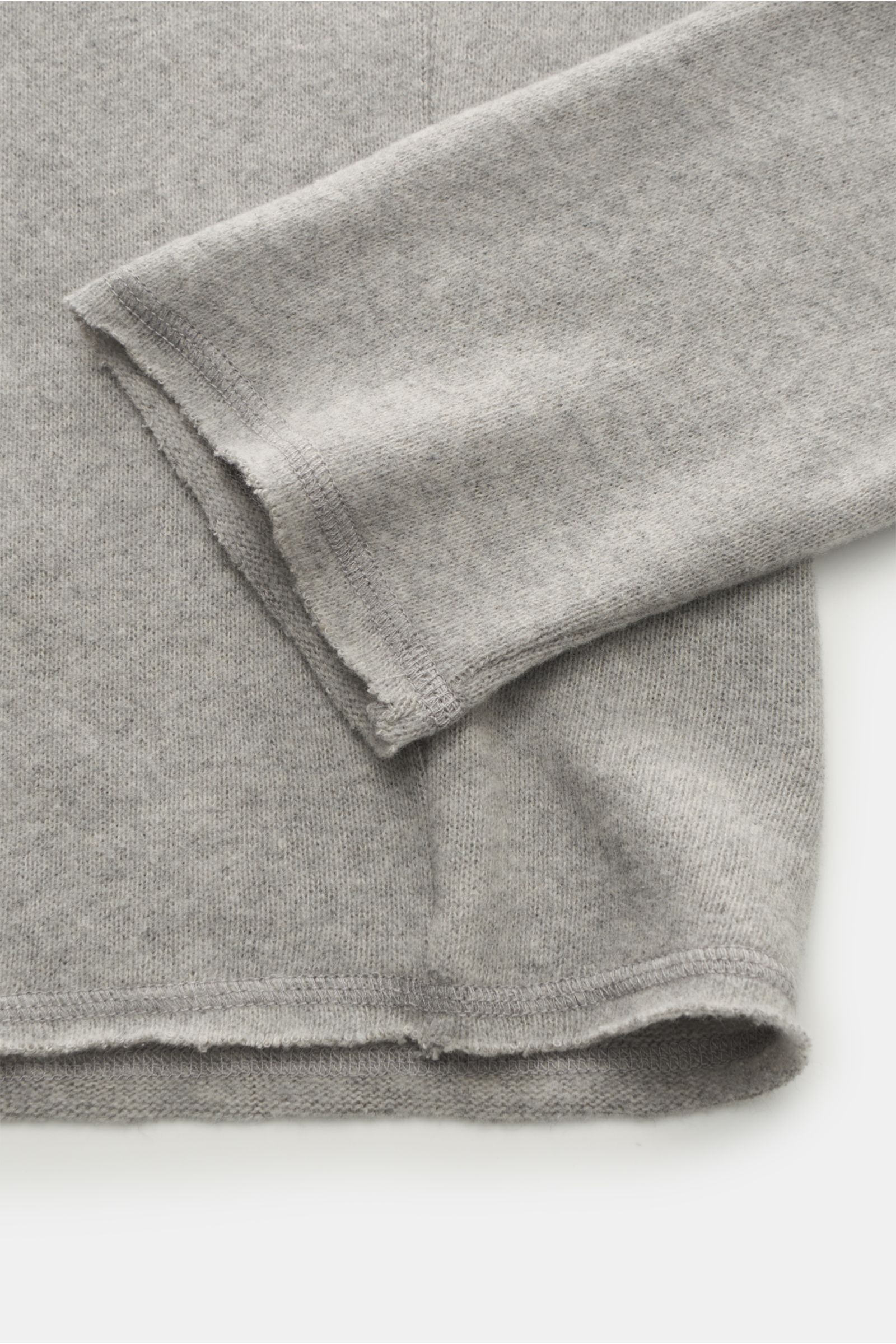 Close-up of Kiefermann Rundhals-Sweatshirt 'Eugeno' hellgrau meliert showing sleeve and hem from a top-down perspective, highlighting open seams and soft texture.

Description: KIEFERMANN trifft den Nerv moderner Minimalisten: Das Rundhals-Sweatshirt '