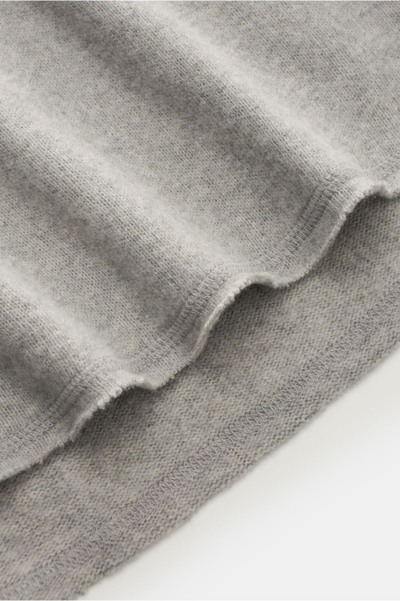 Close-up, angled view of Kiefermann Rundhals-Sweatshirt 'Eugeno' hellgrau meliert showing soft, light fabric with open hem edges. KIEFERMANN trifft den Nerv moderner Minimalisten: Das Rundhals-Sweatshirt 'Eugeno' aus Baumwolle und hochwertiger Microfas