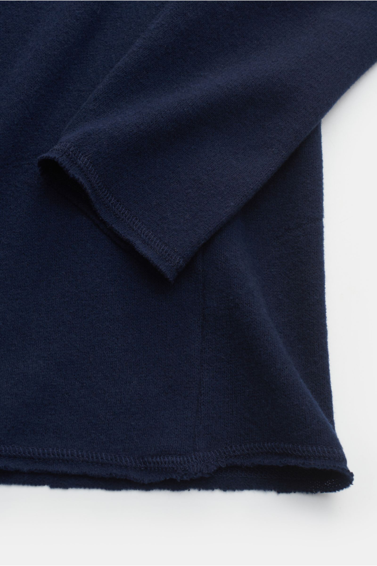 Close-up photo of the sleeve and hem of the Kiefermann Rundhals-Sweatshirt 'Neal' navy, showing its soft fabric and open hem edges from a top-down perspective. 

KIEFERMANN trifft den Nerv moderner Minimalisten: Das Rundhals-Sweatshirt 'Neal' aus Baumw