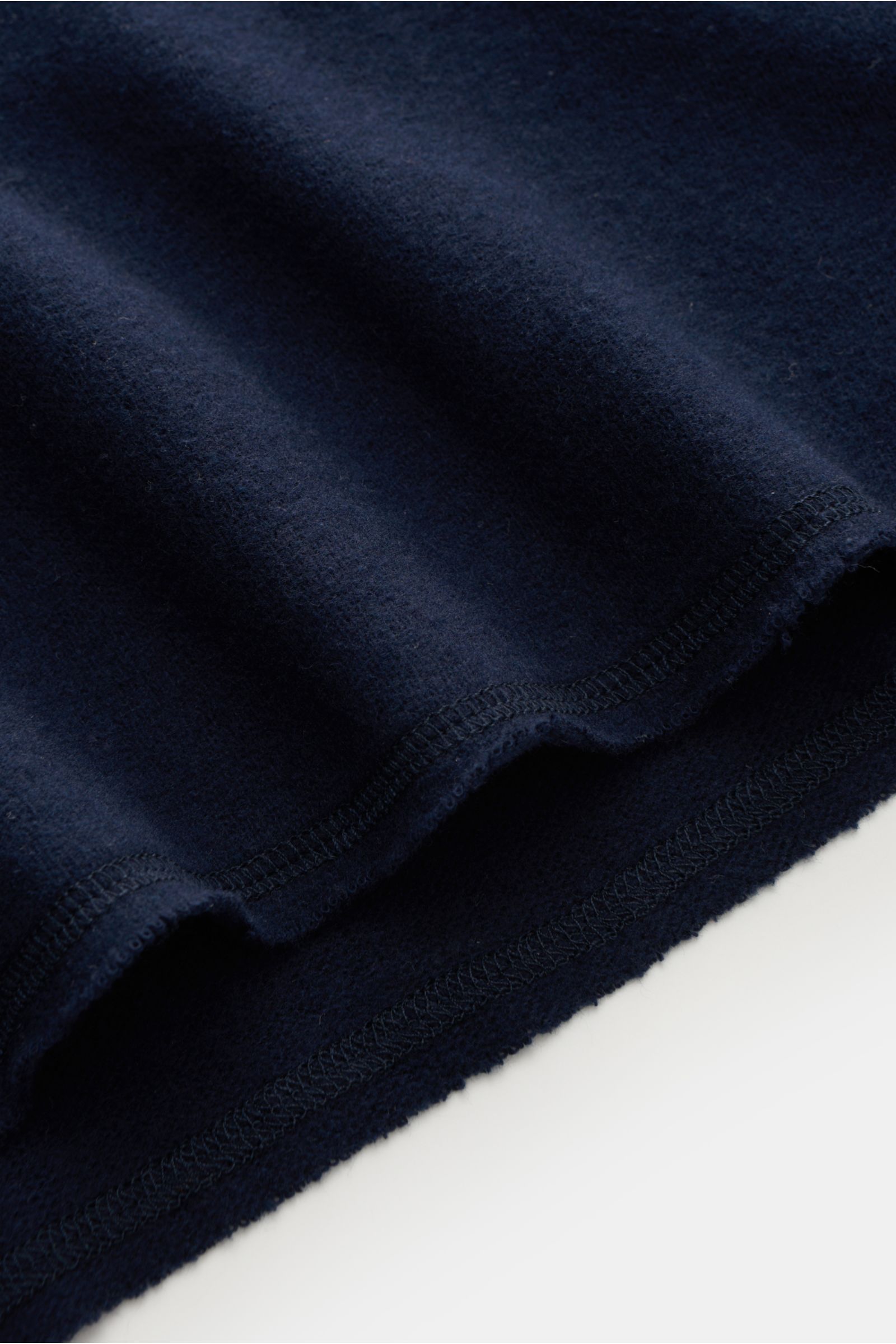 Close-up image of the hem and fabric texture of the Kiefermann Rundhals-Sweatshirt 'Neal' navy, photographed from a side angle. KIEFERMANN trifft den Nerv moderner Minimalisten: Das Rundhals-Sweatshirt 'Neal' aus Baumwolle und hochwertiger Microfaser ist 
