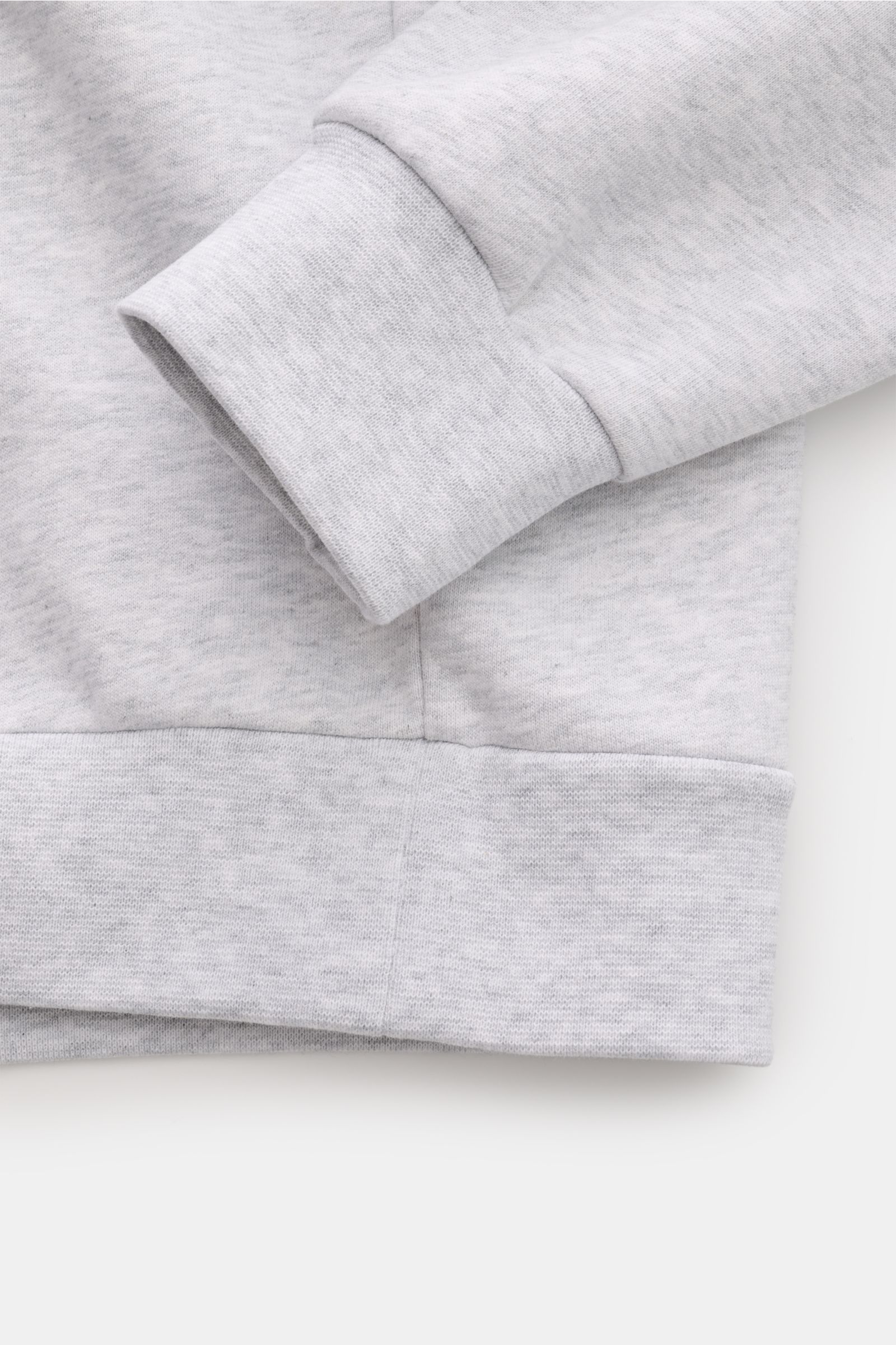 Close-up of the cuff and hem of the A.P.C. Rundhals-Sweatshirt 'Standard Rue Madame' grau meliert, photographed from a top-down angle. Streetwear mit französischem Flair: Das minimalistische Sweatshirt 'Standard Rue Madame' von A.P.C. aus leicht elastisch