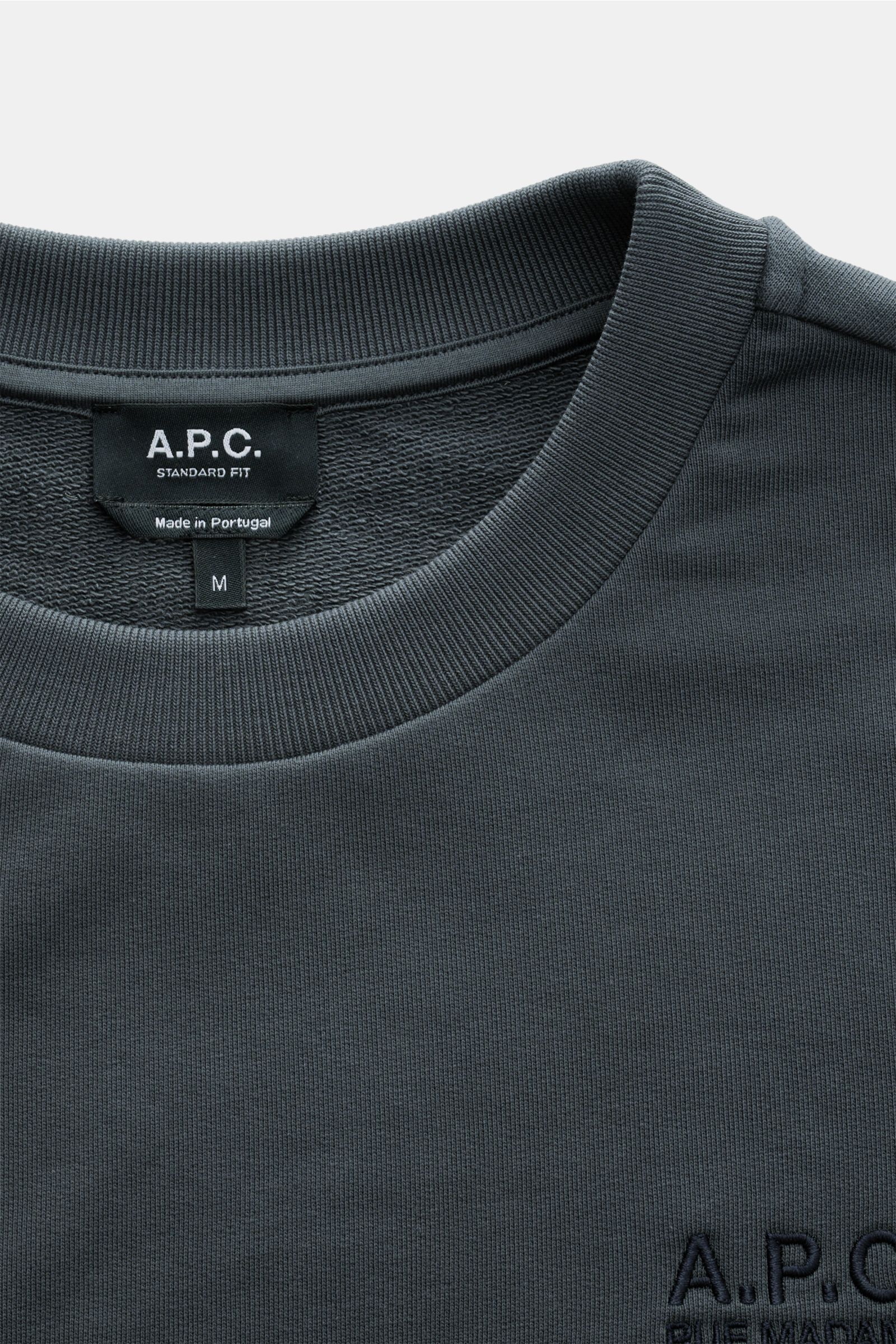 A close-up front view of the A.P.C. Rundhals-Sweatshirt 'Standard Rue Madame' dunkelgrau showing the ribbed round neckline, soft dark gray cotton fabric, and subtle chest logo stitching. Streetwear mit französischem Flair: Das minimalistische Sweatshir