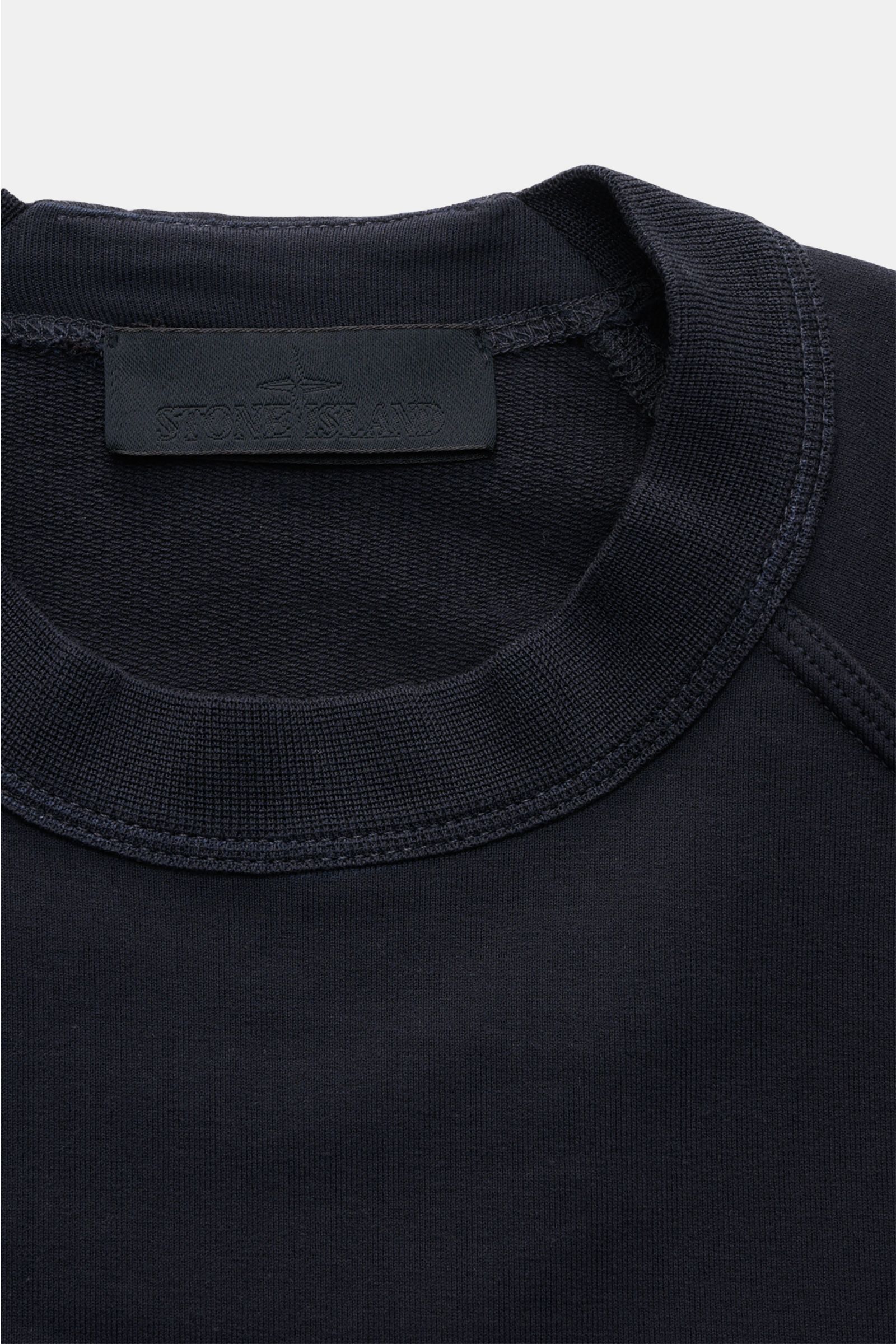 Stone Island Sweatshirt 'Ghost Piece' navy aus elastischer Baumwolle mit Rundhalsausschnitt, Raglanärmeln und tonalem Kompass-Badge, Detailfoto von oben.