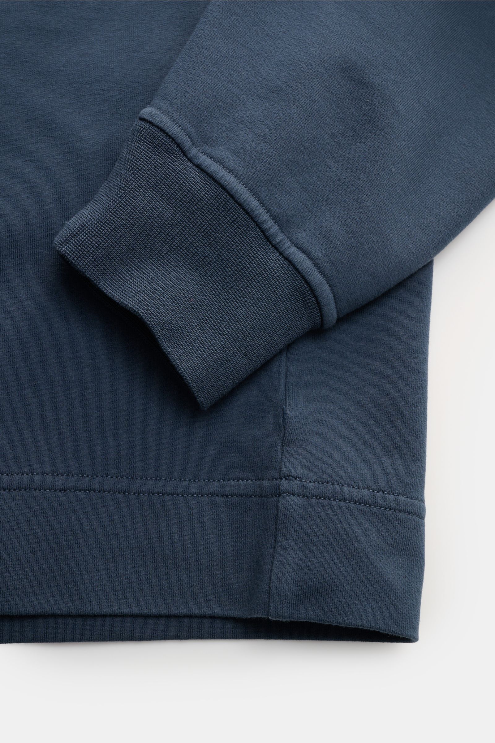 Stone Island Sweatshirt 'Ghost Piece' graublau shown from close-up side view, highlighting cuff and hem details. STONE ISLAND bietet mit diesem Sweatshirt aus elastischer Baumwolle mit tonalem Kompass-Badge am Ärmel einen komfortablen Allrounder aus de