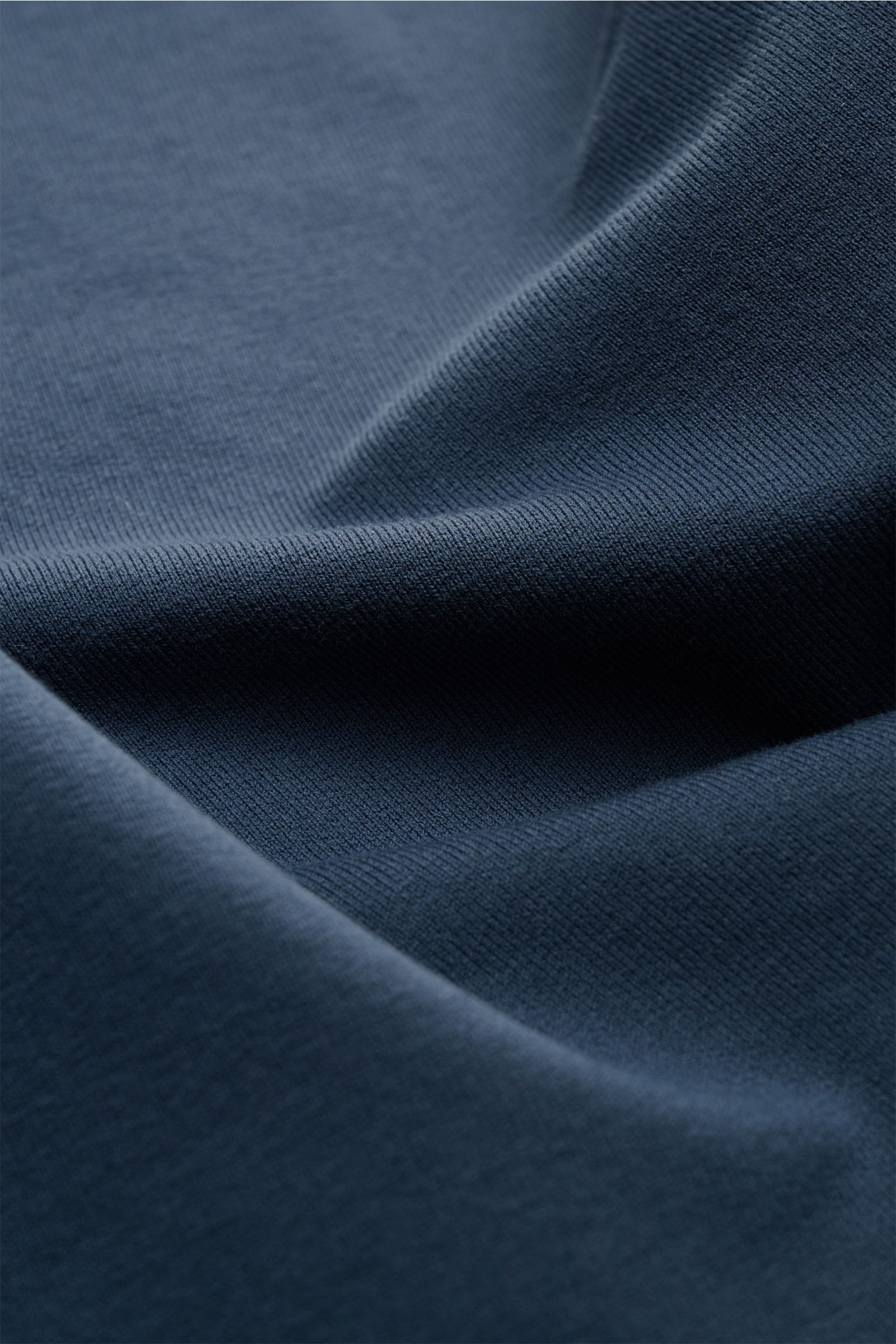 Close-up fabric detail of the Stone Island Sweatshirt 'Ghost Piece' graublau, showing soft, slightly elastic cotton from a top-down perspective. STONE ISLAND bietet mit diesem Sweatshirt aus elastischer Baumwolle mit tonalem Kompass-Badge am Ärmel einen k