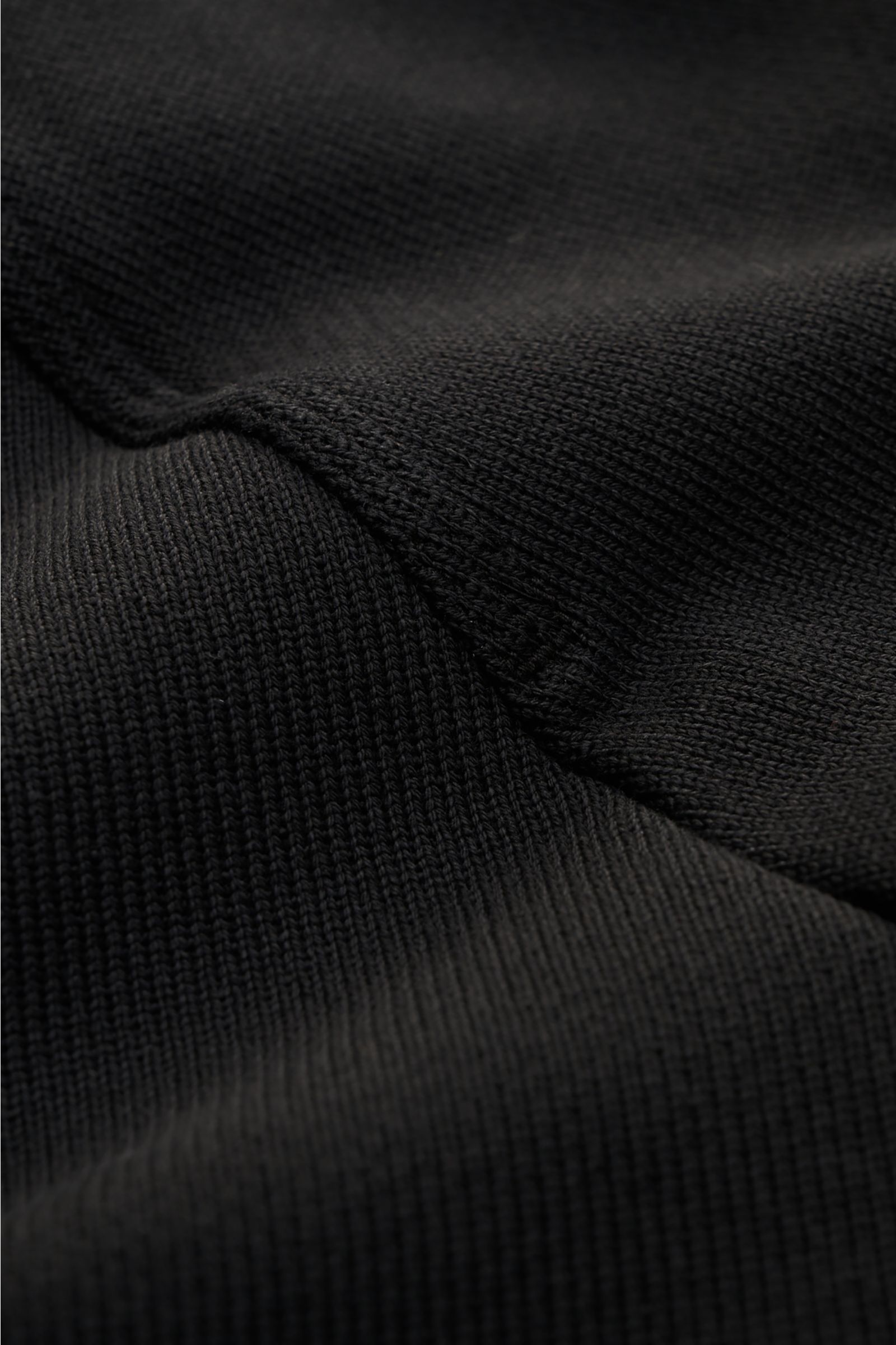 Nahaufnahme des schwarzen Stone Island Rundhals-Sweatshirts 'Ghost Piece' mit strukturierter Baumwollqualität, Raglanärmel und tonalem Kompass-Badge.