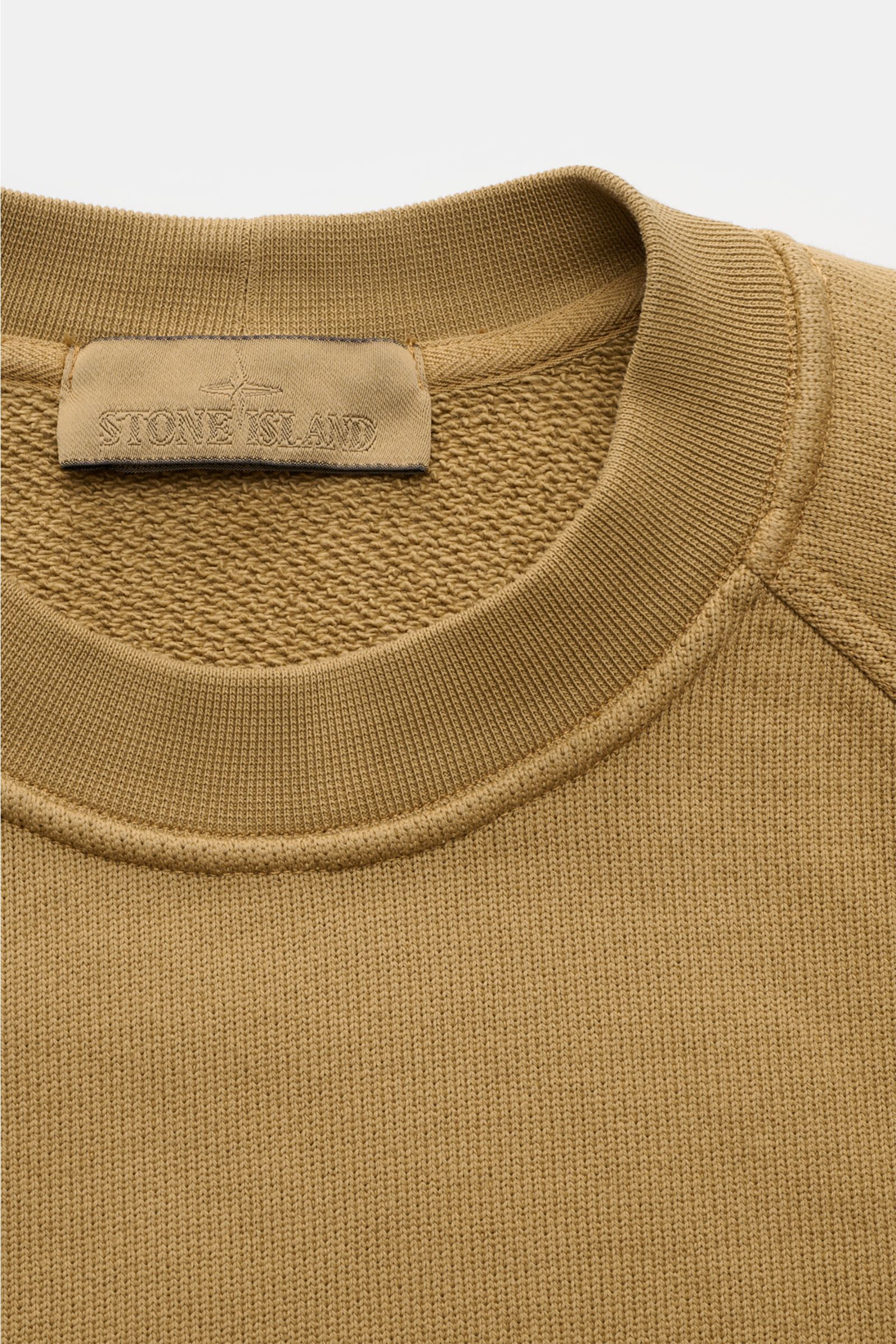 Stone Island Rundhals-Sweatshirt 'Ghost Piece' hellbraun, Baumwolle, Regular Fit, Raglanärmel, tonales Badge, Rippbündchen, Detailansicht von oben.