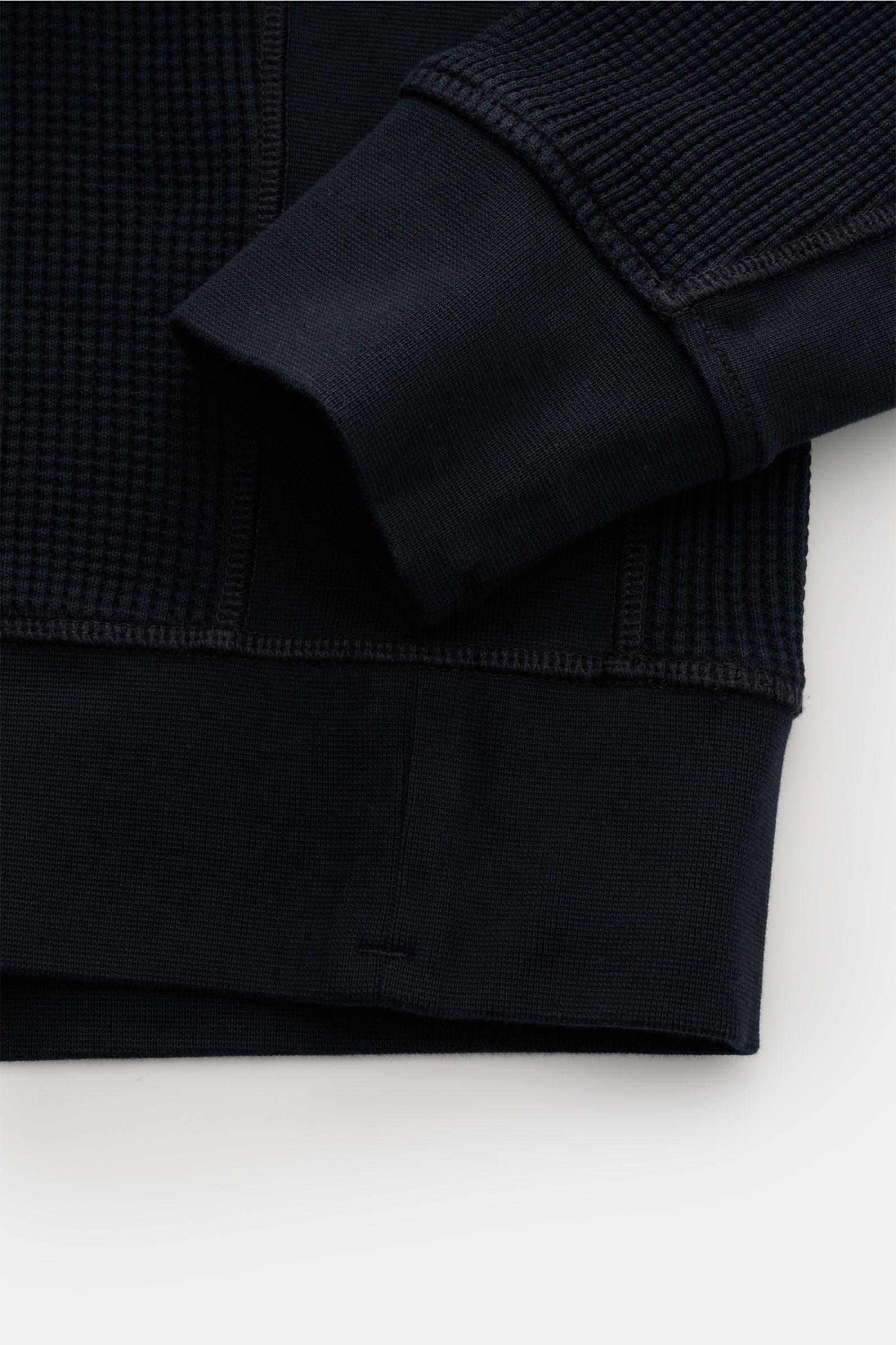 Close-up front view of Stone Island Rundhalspullover 'Waffle' navy, showing waffle-knit cotton fabric, slim fit cuff, and sweatband details.

Basic Piece mit Twist: Dieser Pullover im Waffelstrick von STONE ISLAND wird zur idealen Grundlage moderner Fr