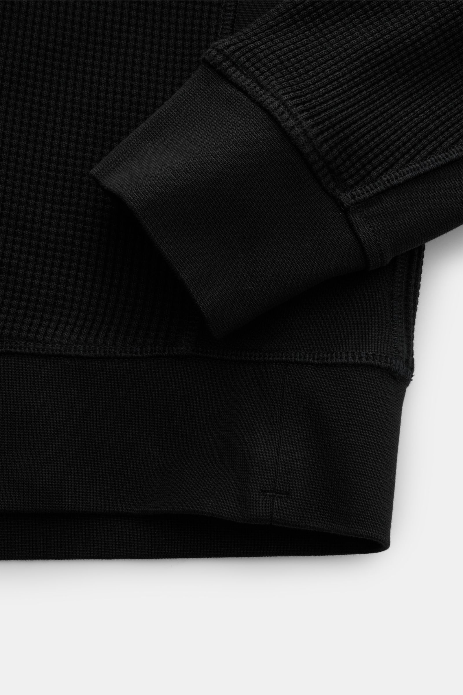 Stone Island Rundhalspullover 'Waffle' schwarz, Detailaufnahme von Bündchen und Waffelstrick aus reiner Baumwolle, Slim Fit, Kompass-Badge am Ärmel.