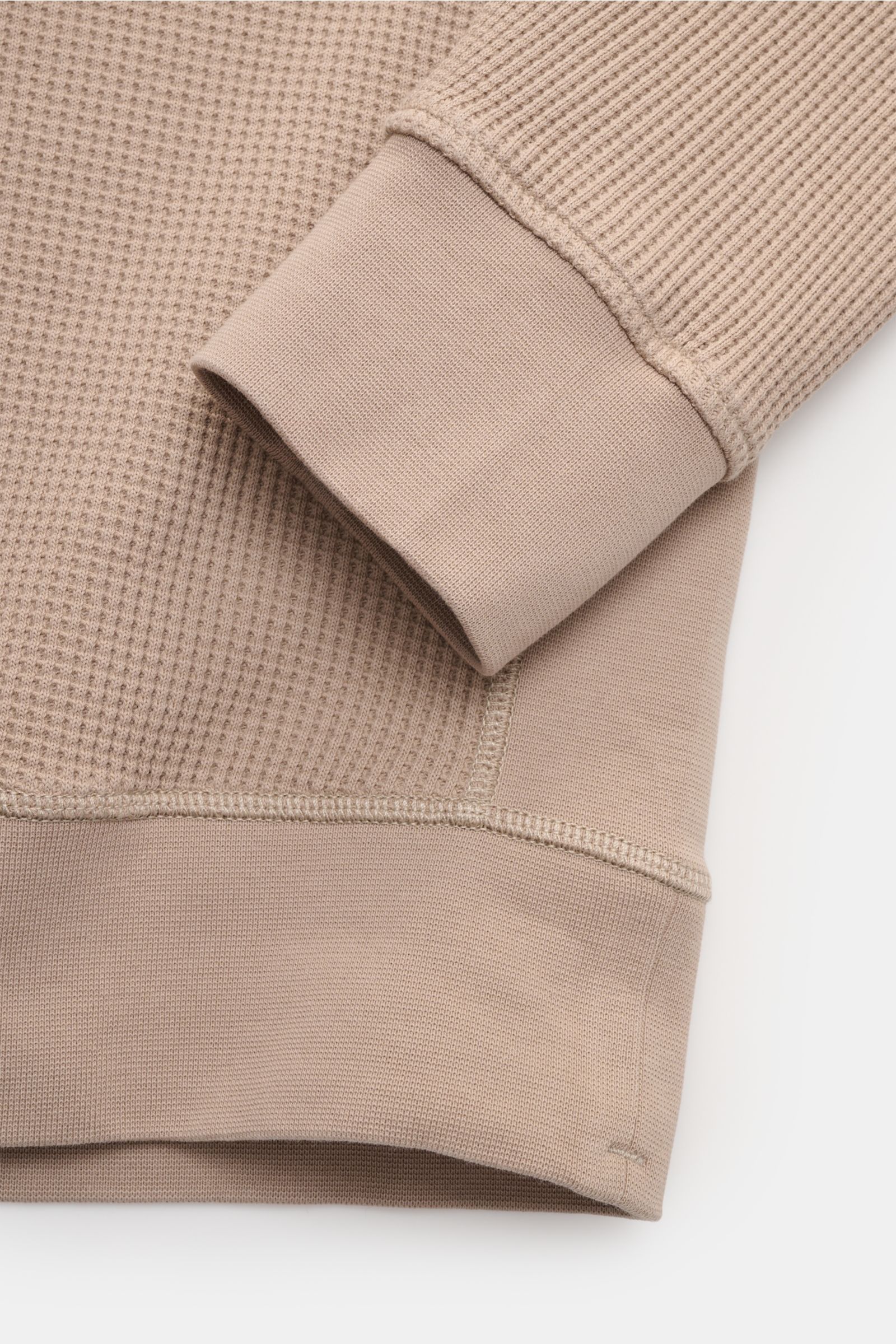 Stone Island Rundhalspullover 'Waffle' taupe close-up from above showing waffle-knit cotton fabric, ribbed cuff, and sweatband details. Basic Piece mit Twist: Dieser Pullover im Waffelstrick von STONE ISLAND wird zur idealen Grundlage moderner Freizeitloo