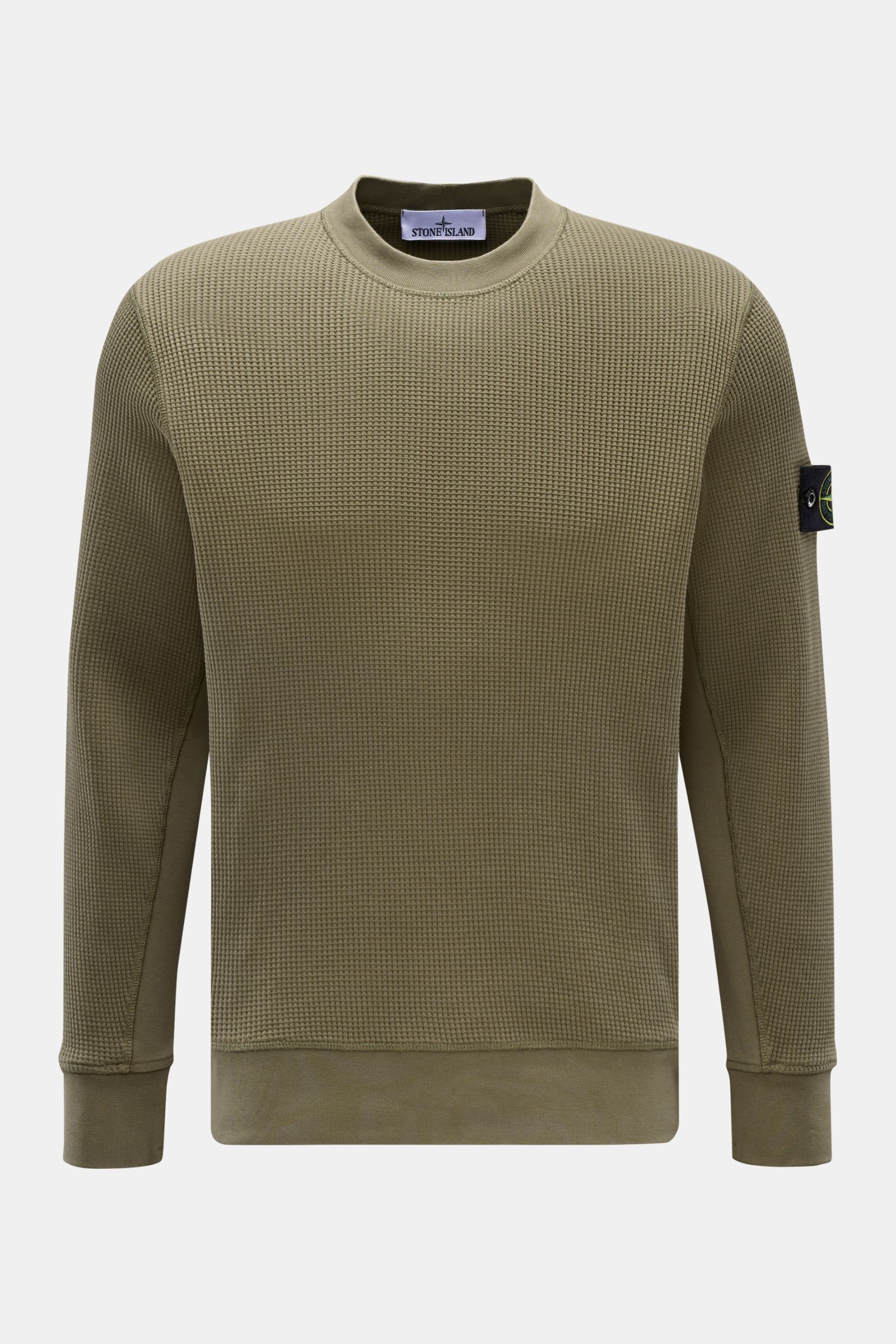 Front view of Stone Island Rundhalspullover 'Waffle' oliv, an olive green slim-fit crewneck sweater in waffle knit with sweat cuffs and compass badge on upper arm. 

Basic Piece mit Twist: Dieser Pullover im Waffelstrick von STONE ISLAND wird zur ideal