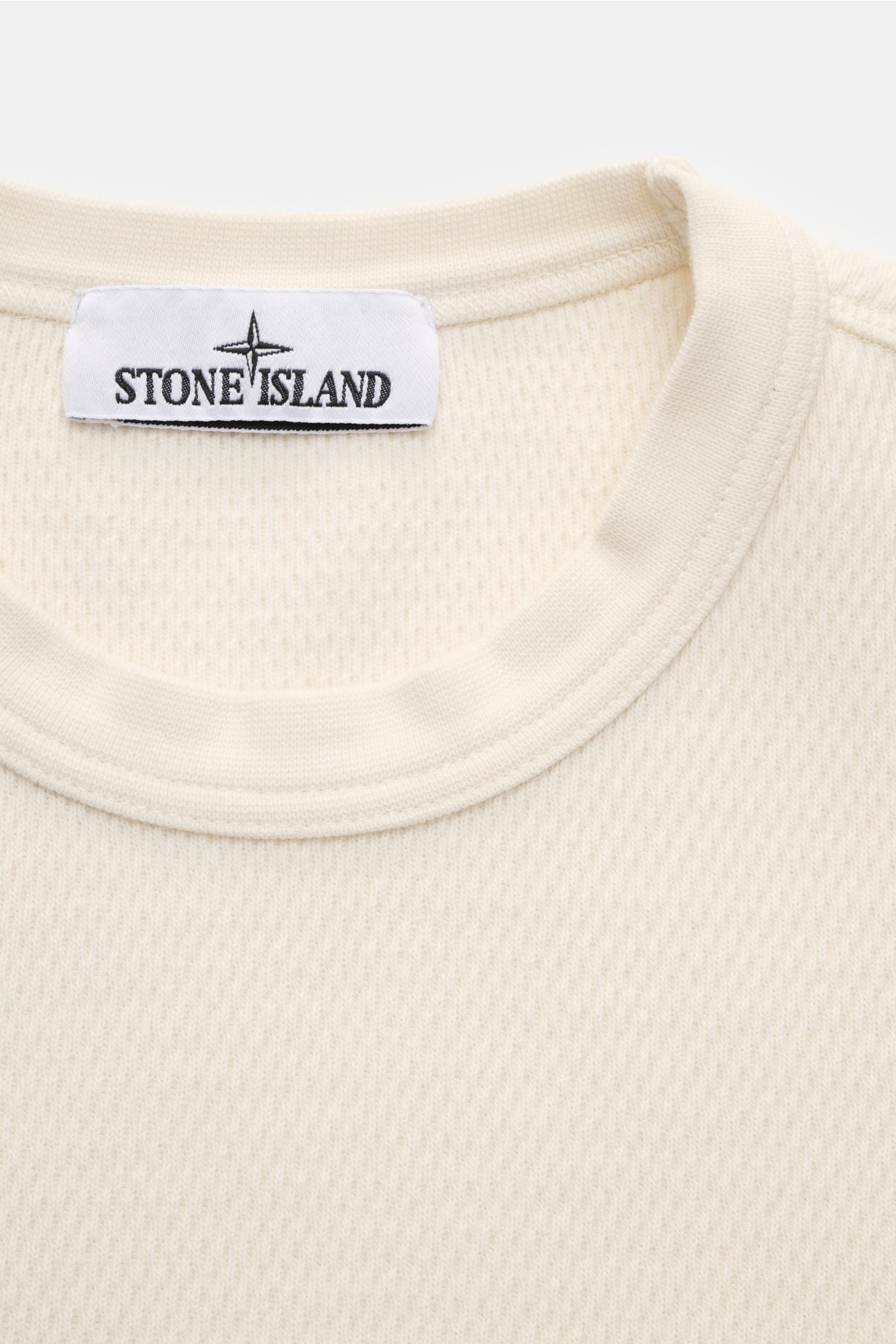 Stone Island Rundhalspullover creme in Frontansicht, strukturierte Jersey-Qualität, Rundhalsausschnitt, Overlock-Nähte, Kompass-Badge am Oberarm.