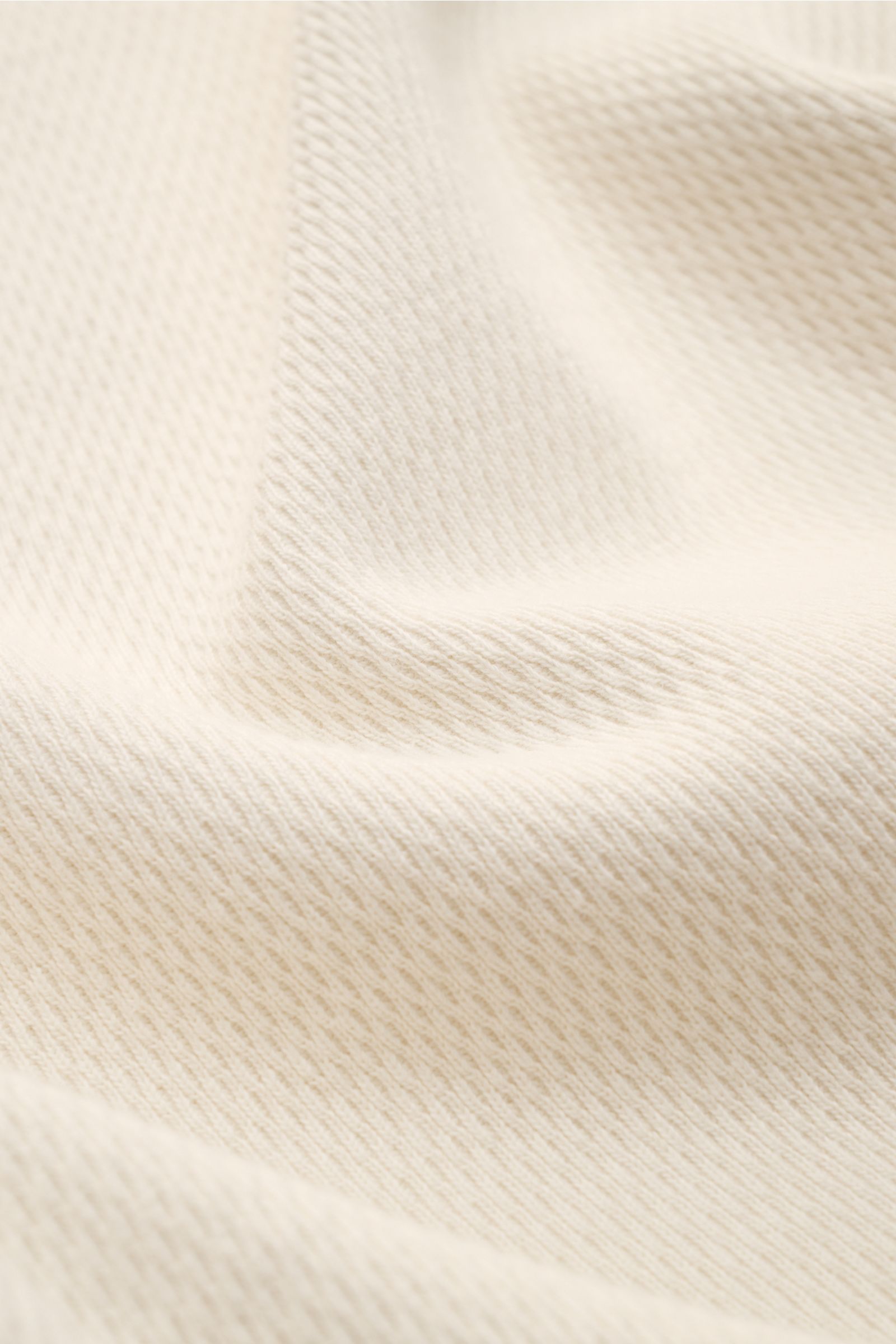Stone Island Rundhalspullover creme, Nahaufnahme der strukturierten Jersey-Baumwolloberfläche mit feinem Strickbild und weichen Falten.